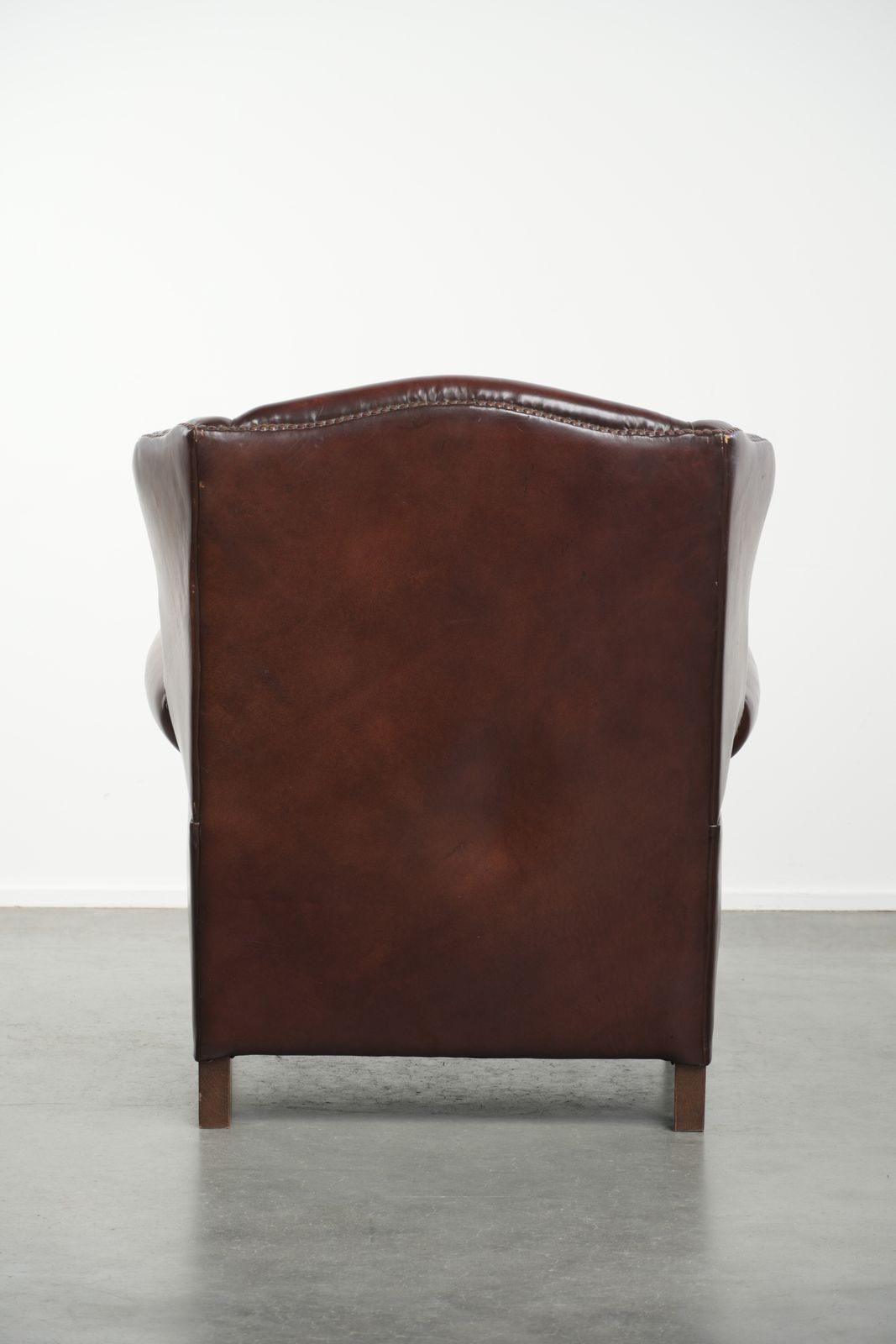 Elegante Vintage Schapenvacht Vleugelfauteuil Met Een Tijdloze Engelse Uitstraling, Afgewerkt Met Decoratieve Sierspijkers. photo Meubels