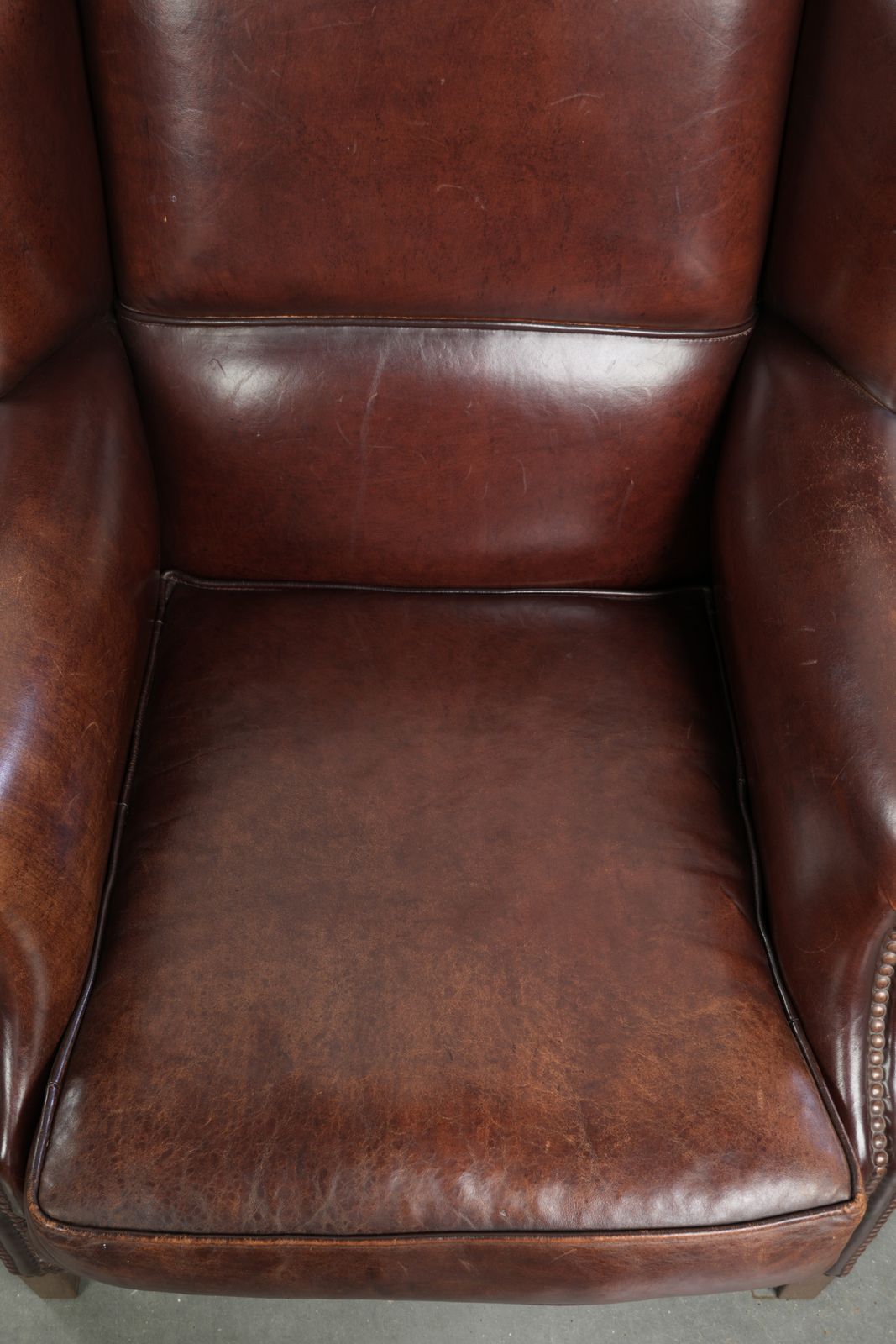 Elegant Vintage Sheepskin Wing Armchair With A Timeless English Look, Finished With Decorative Nails. photo vinterior
