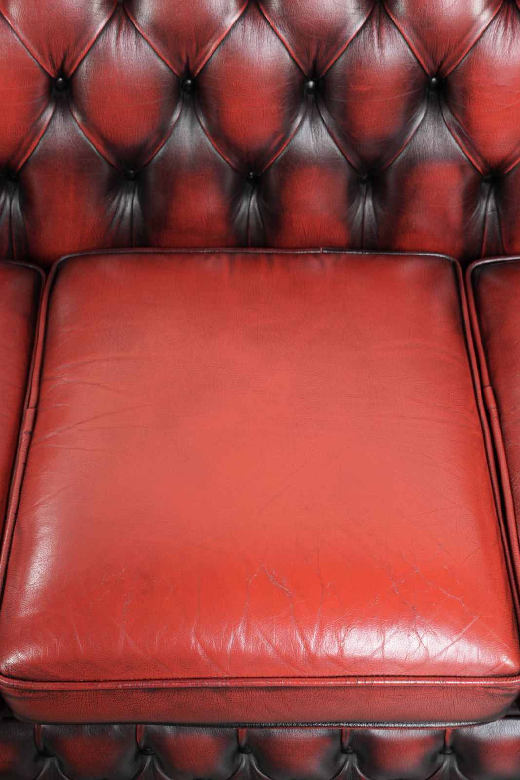 Engelse Chesterfield 2,5/3-zitsbank van koeienleer in een luxueuze rode kleur. photo vinterior