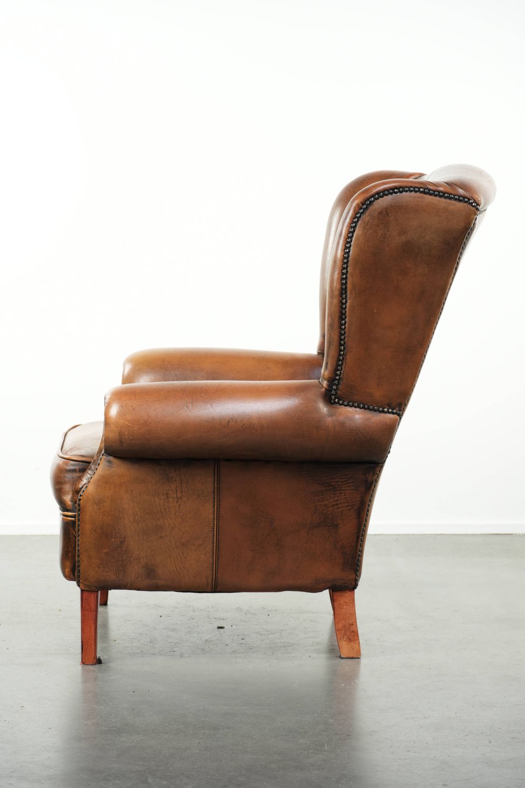 Comfortable Wing Armchair Made Of Sheepskin Finished With Decorative Studs And A Characterful English Style Appearance. photo 990.0