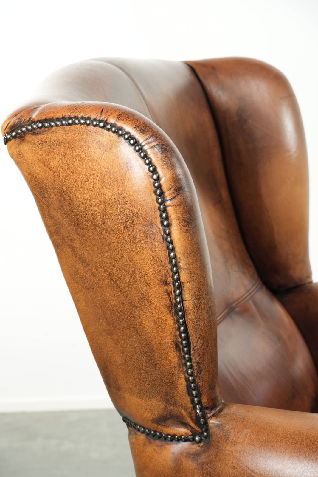 Furniture Comfortable Wing Armchair Made Of Sheepskin Finished With Decorative Studs And A Characterful English Style Appearance. photo