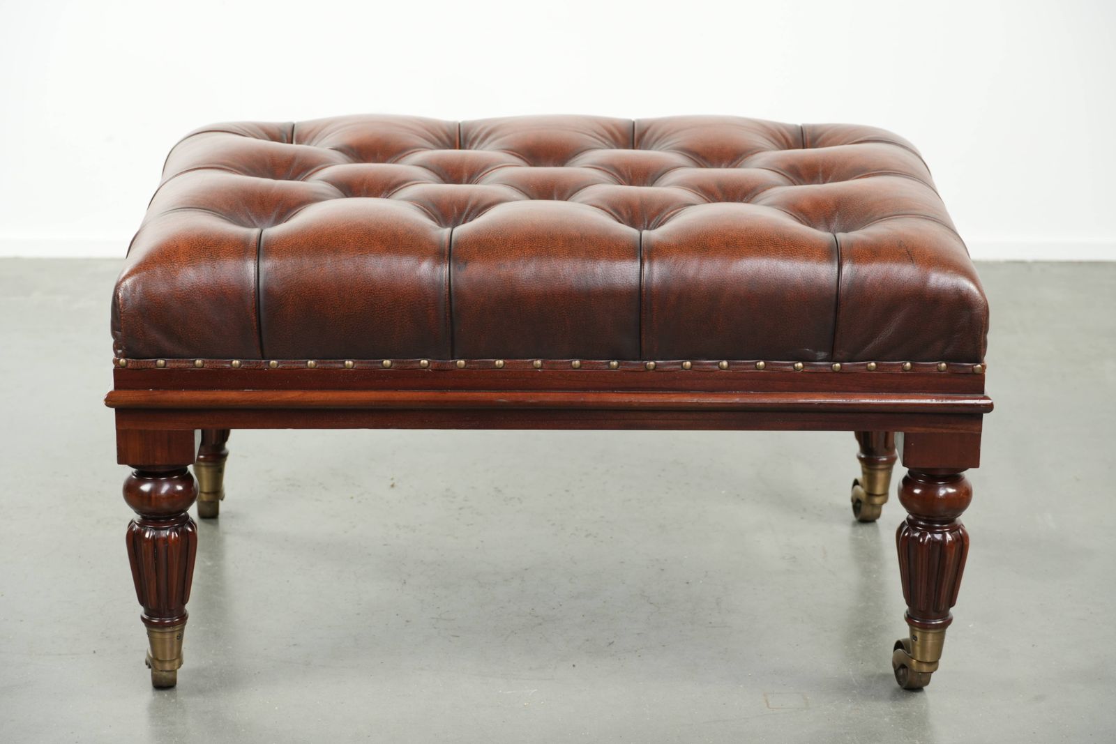 Large Brown Cowhide Chesterfield Ottoman In English Style With Elegant Legs And Brass Casters photo Furniture