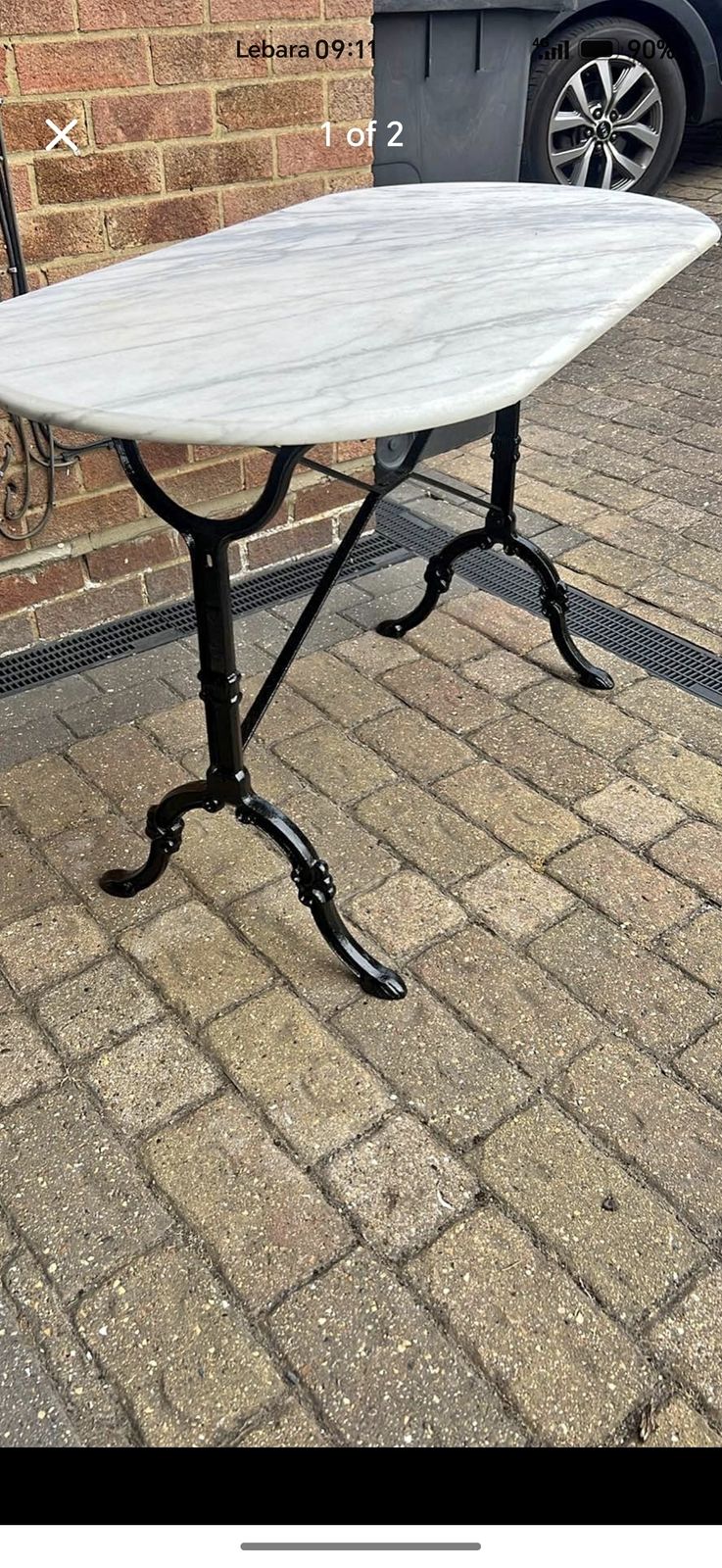 Antique Style Bistro Table Features An Oval White Marble Top Resting On A Black Cast Iron Base. photo Garden Furniture