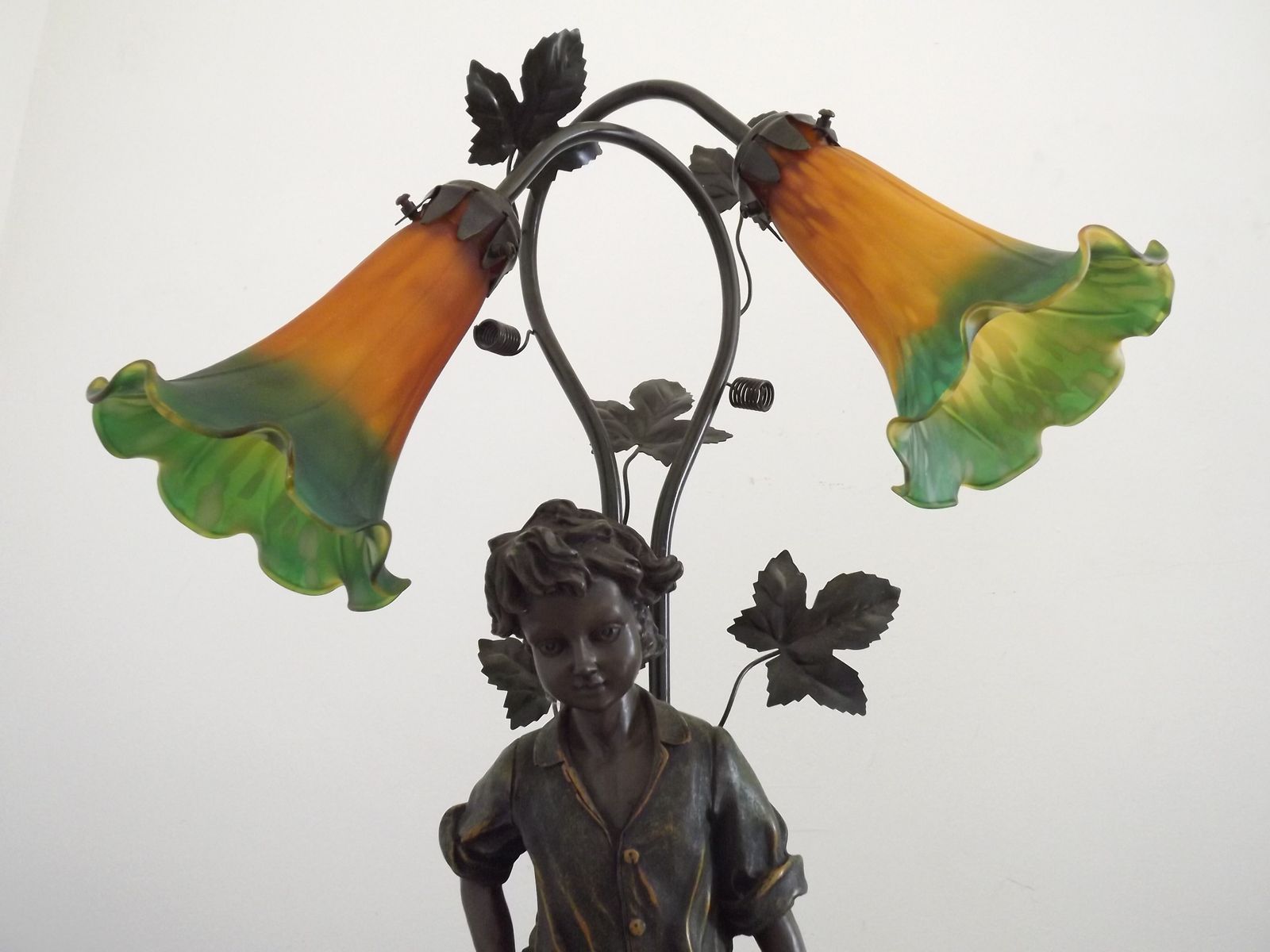 345.0 Art Nouveau tafellamp met jongensbeeldje en tulpvormige kappen in amber en groen glas photo