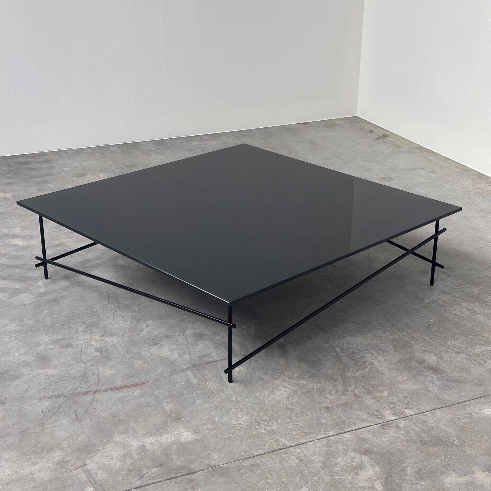 Minimalistische salontafel van zwart glas met industrieel metalen onderstel