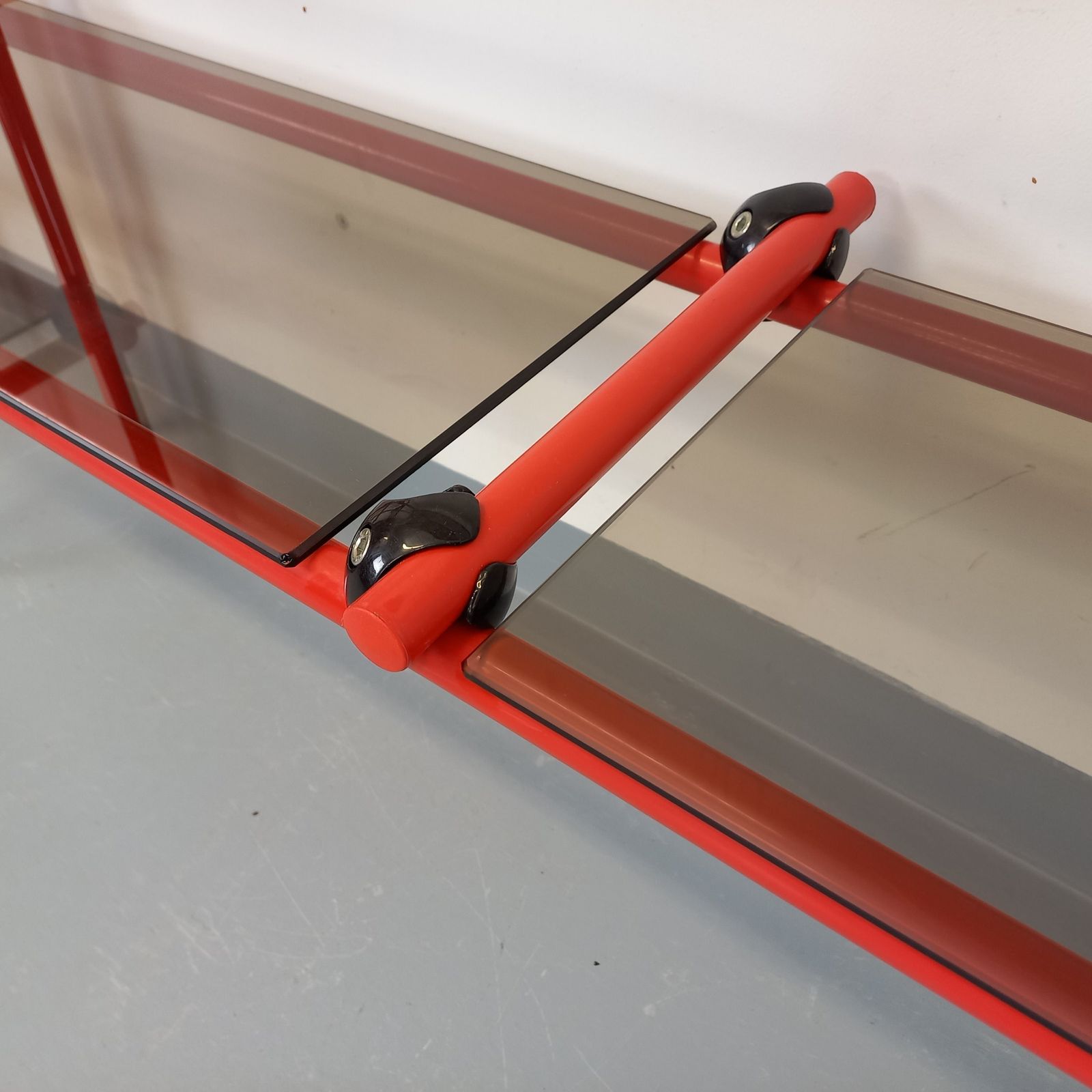 Italiaanse boekenkast in Bauhaus-stijl, rood metaal en rookglas photo vinterior