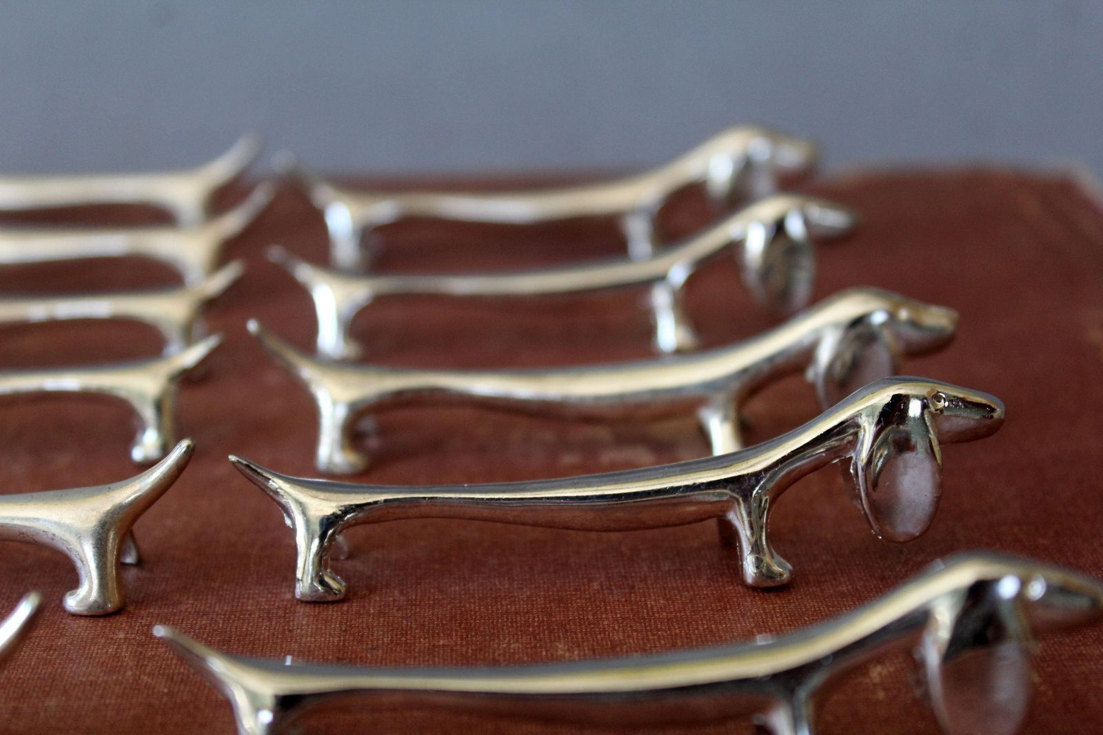 Woonaccessoires Vintage set van 11 zilvergekleurde messenleggers met hond, teckel, dierenfiguur – voor aan de eettafel, geschikt als stokjeslegger en besteklegger photo