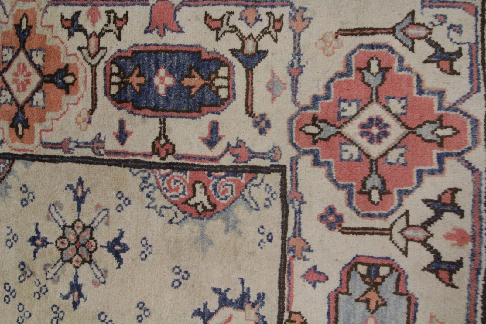 photo furniture Tapis oriental fait main, médaillon central sur fond crème, symétrique