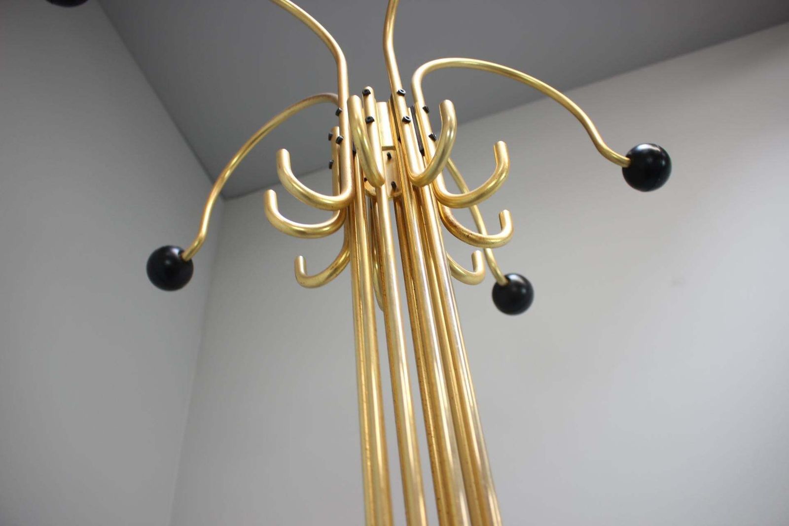 photo furniture Italiaanse Postmodern kapstok van messing met zwarte houten eindknoppen, ca. 1980–1985