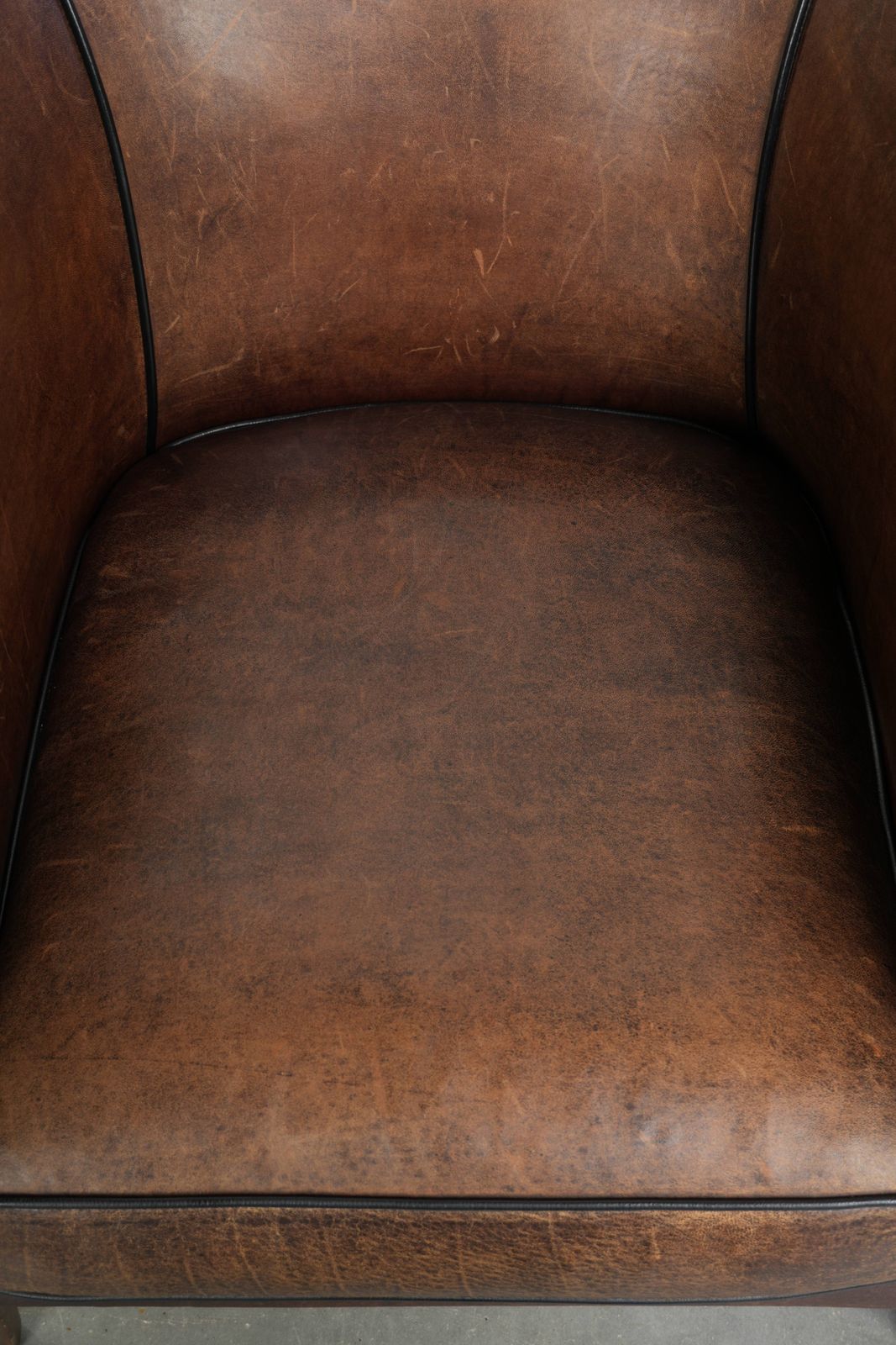 Strakke art deco schapenvacht club fauteuil met zwarte biesafwerking photo vinterior