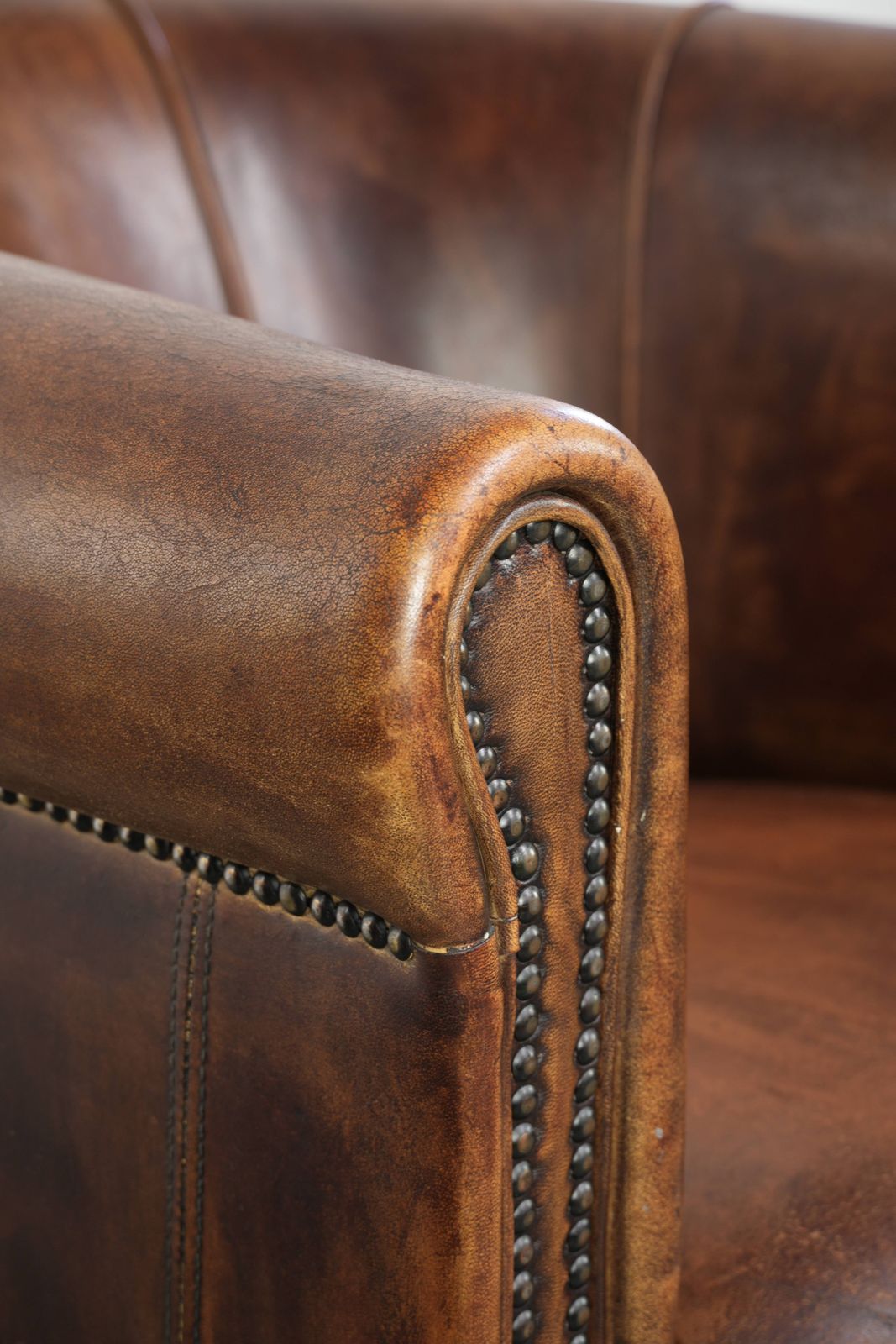 Meubels Stevige en karaktervolle clubfauteuil in schapenleer met een mooie patina, afgewerkt met decoratieve nagels. photo