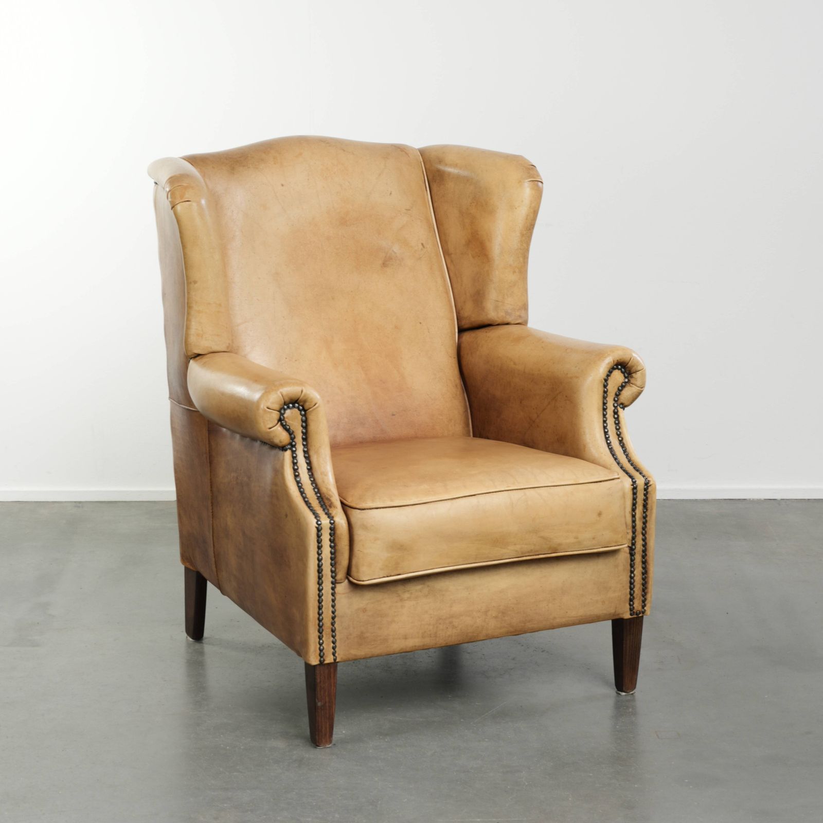 Lichte koeienhuid fauteuil met vleugelleuningen, een mooie tijdloze Engelse uitstraling en goed zitcomfort.