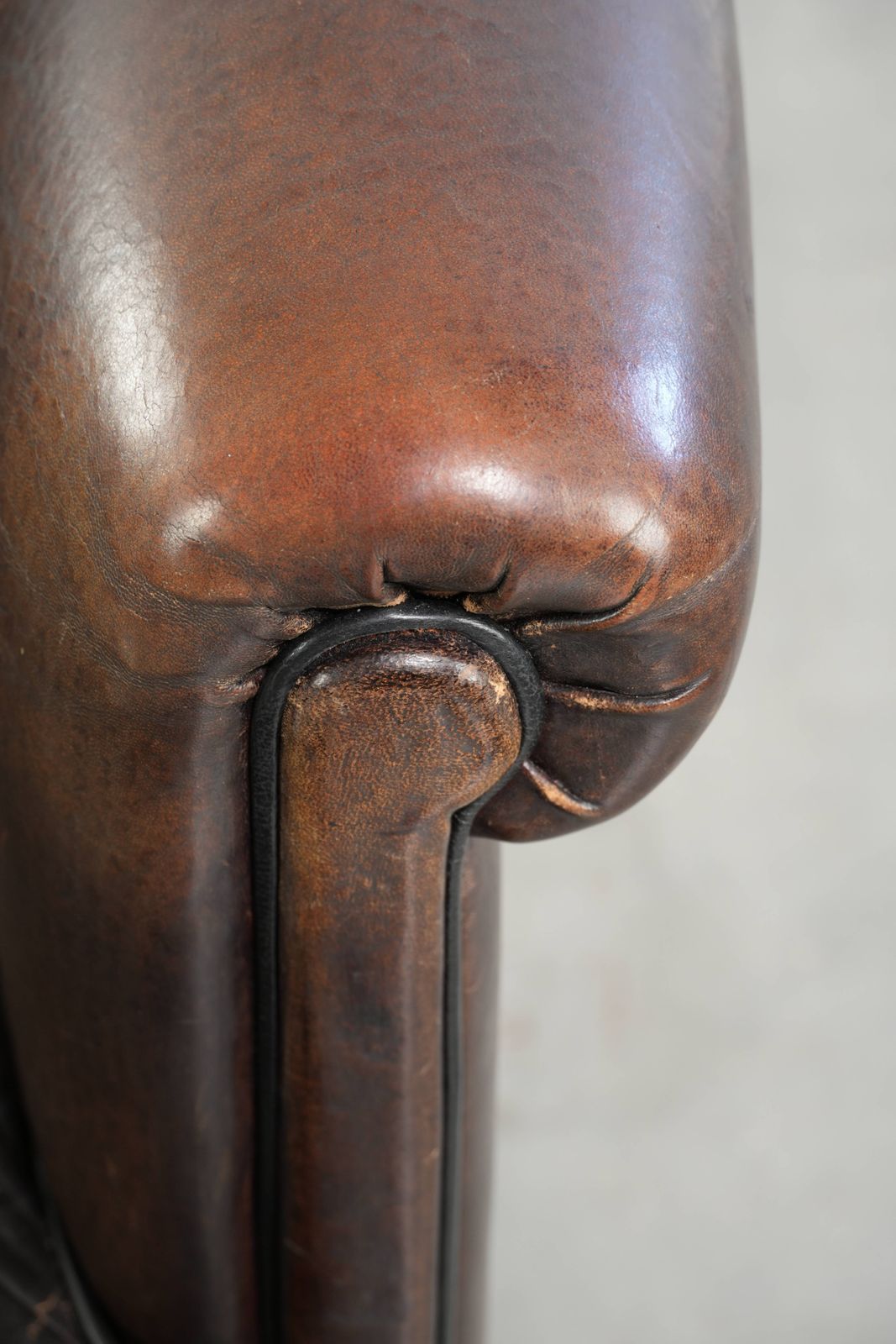 photo for sale Donkere schapenleren club fauteuil met uniek ontwerp en aantrekkelijke patina in Engelse stijl.