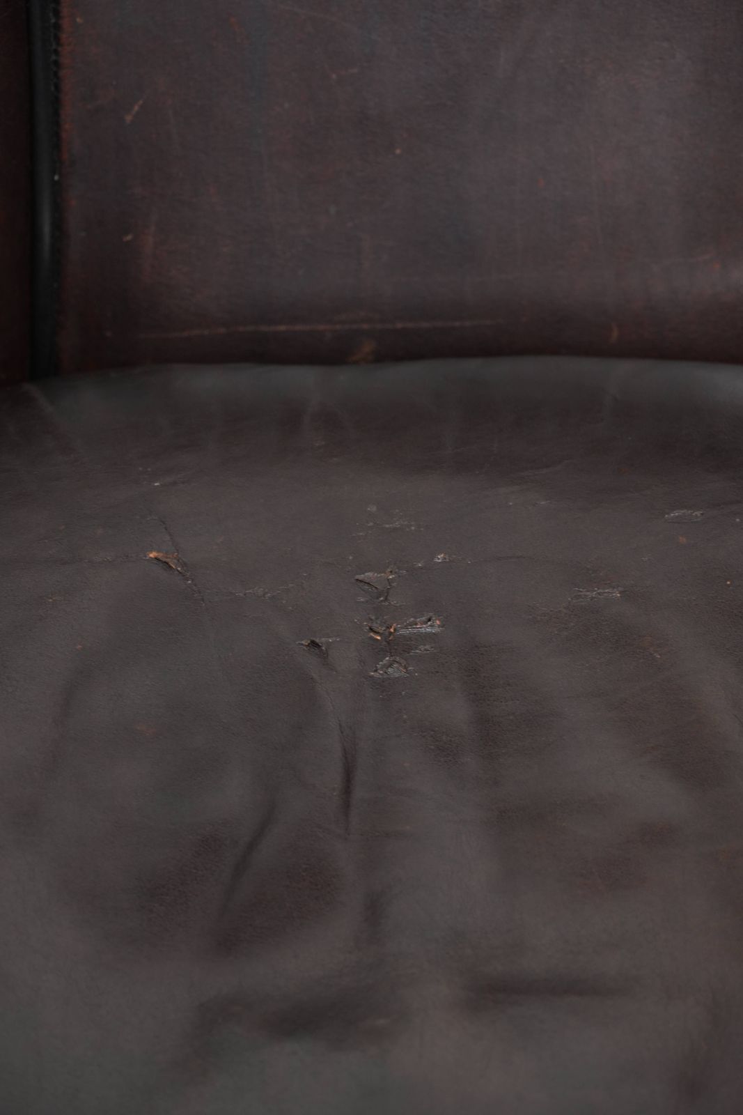 photo vinterior Donkere schapenleren club fauteuil met uniek ontwerp en aantrekkelijke patina in Engelse stijl.