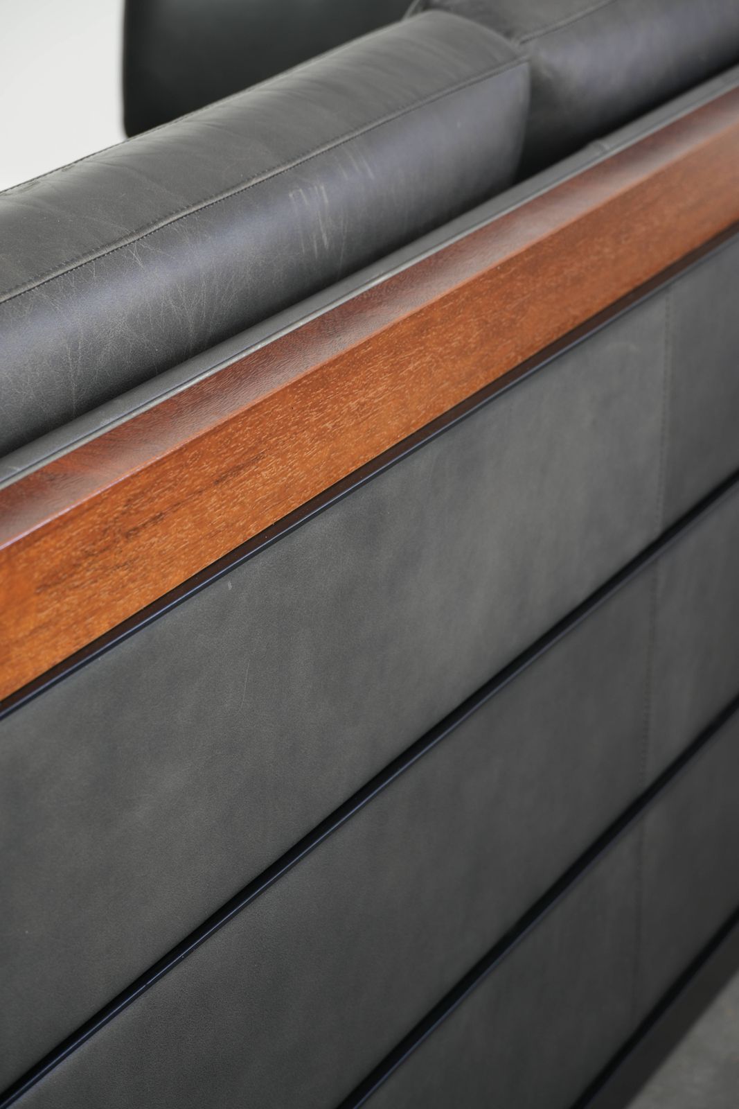 photo furniture Tijdloze 3-zitsbank, art deco design, bekleed met zwart koeienleer en afgewerkt met houten details