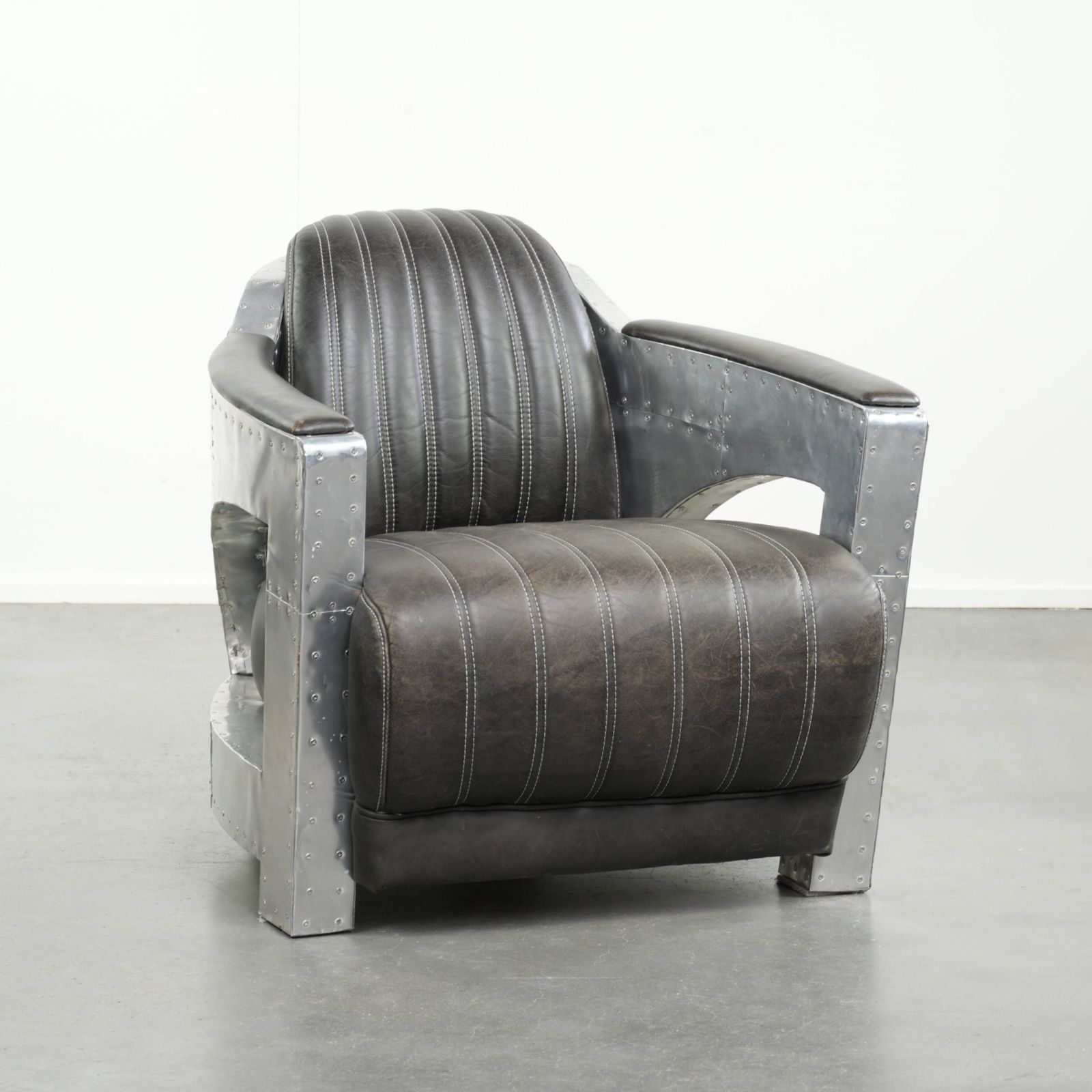 Unieke en comfortabele fauteuil in Aviator-stijl van koeienhuidleer met aluminium afwerking en klinknagels