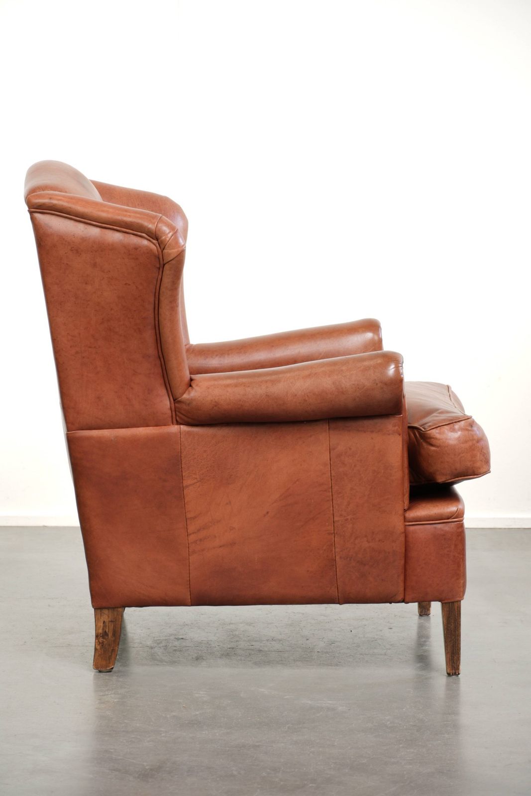 Light Cognac Colored Cowhide Wing Armchair With Matching Piping And A Characterful English Look. photo for sale