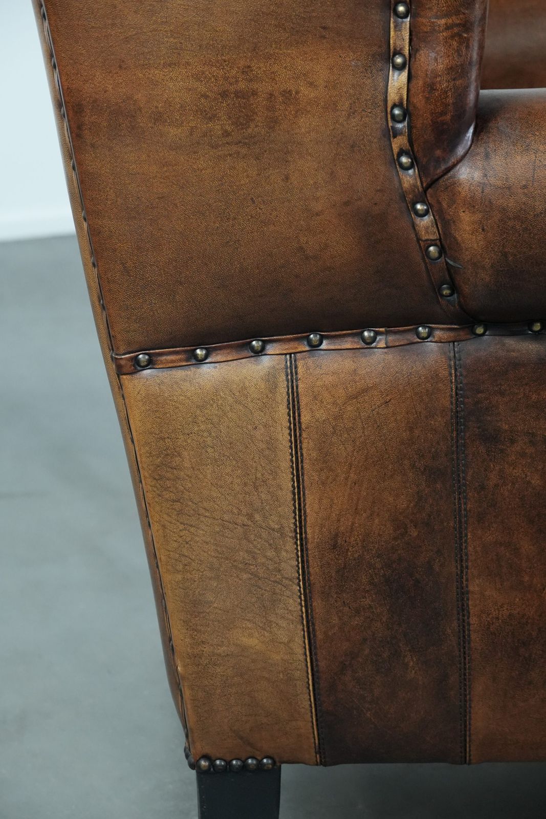 photo buy Timeless And Comfortable Sheepskin Wing Armchair With Beautiful Colors And A Finish With Decorative Nails And Black Piping.