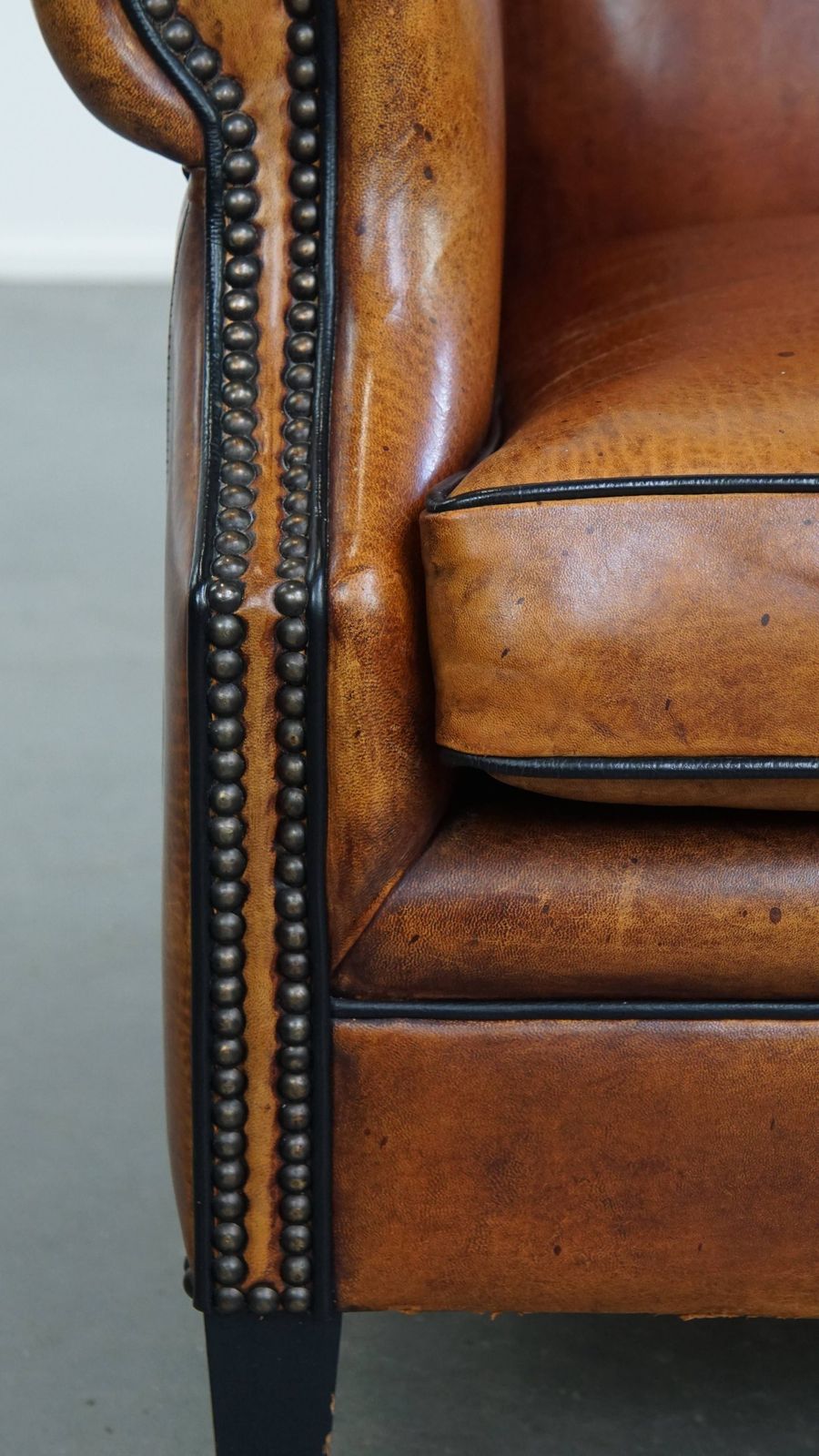 1245.0 Comfortabele schapenvachten oorfauteuil met warme kleurstelling en afwerking met stiksels en zwart biesje. photo