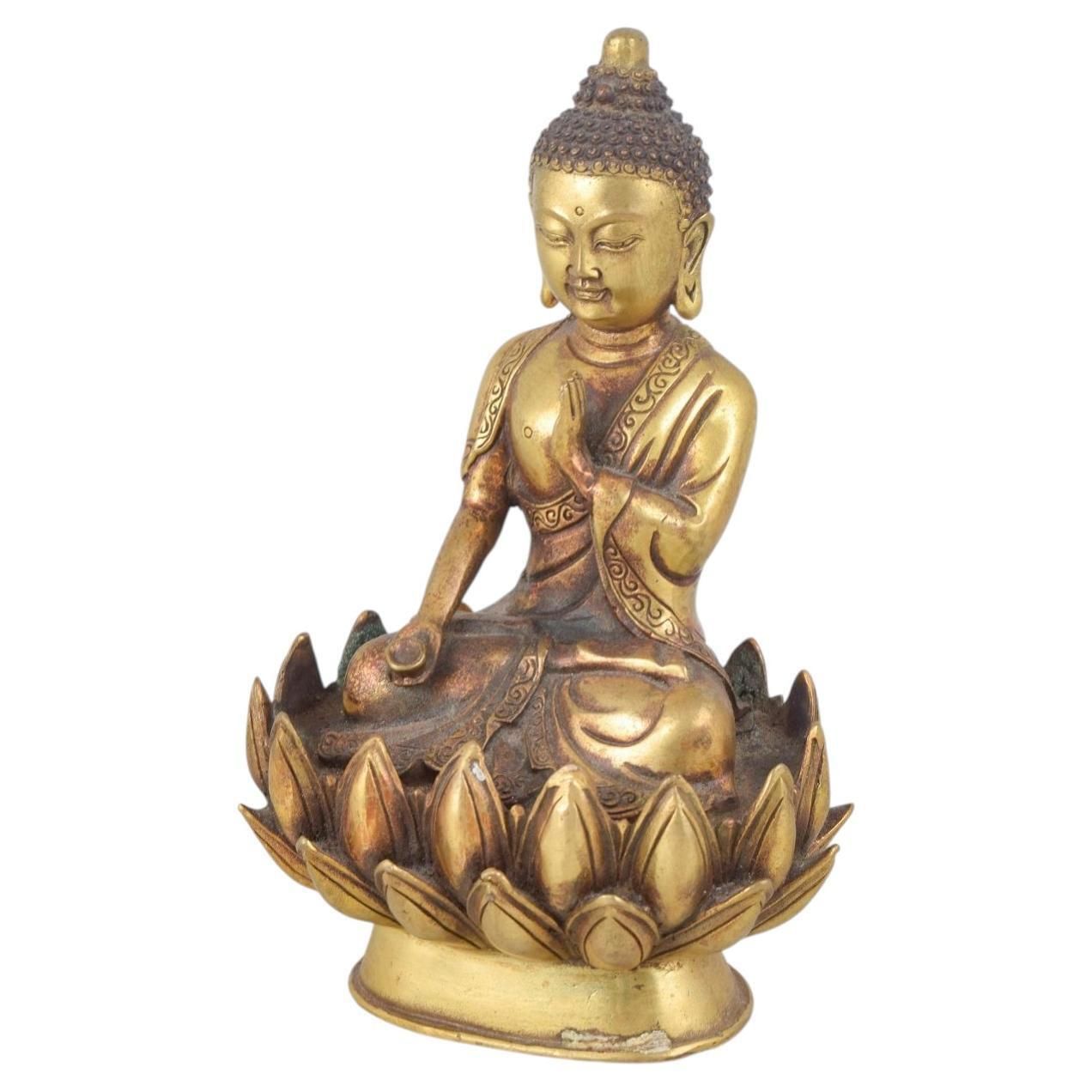 Statuette de Bouddha assis en bronze doré, une main levée. Asie, XIXe siècle