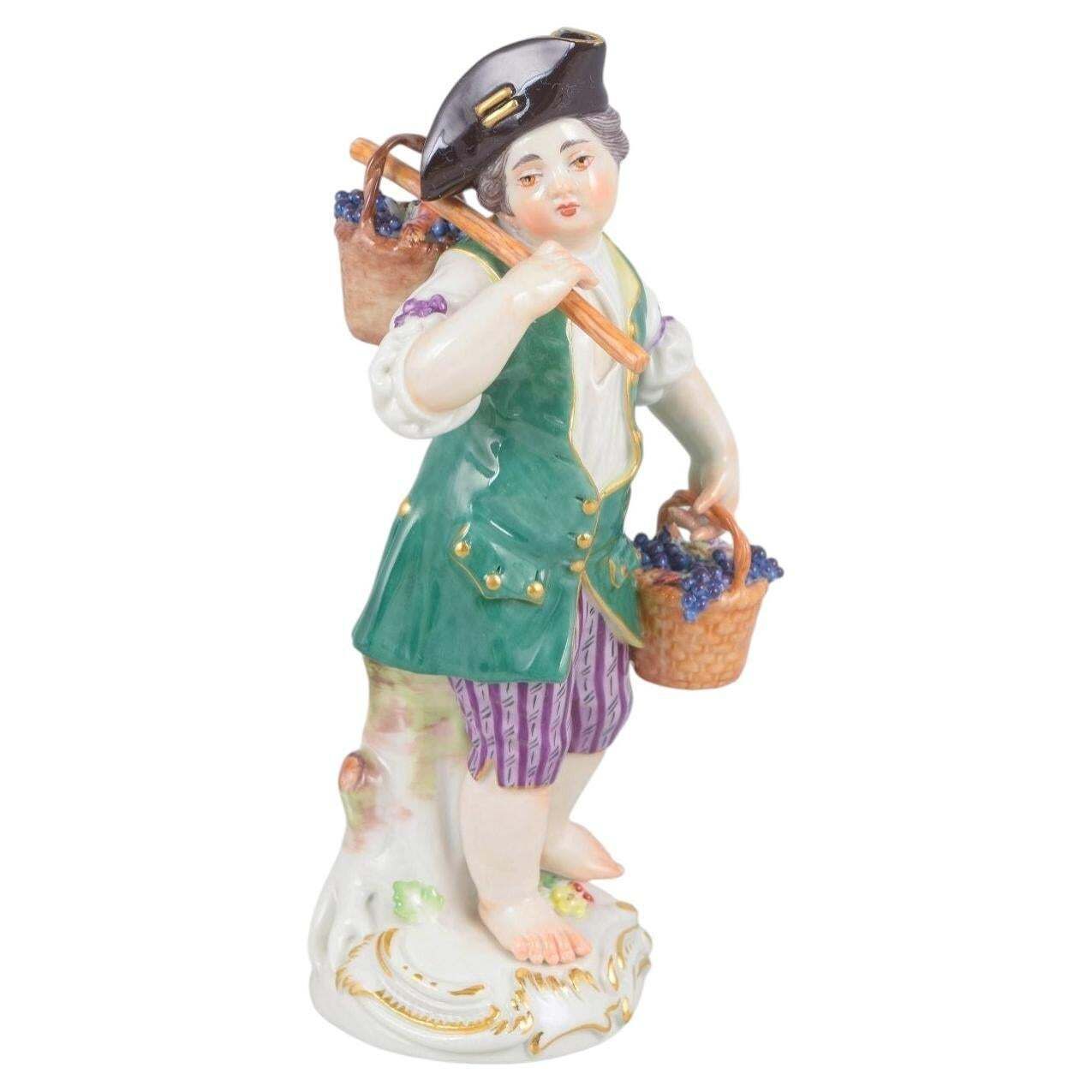 Meissen, Allemagne. Figurine en porcelaine d'un garçon aux paniers de raisins. Début du XXe siècle