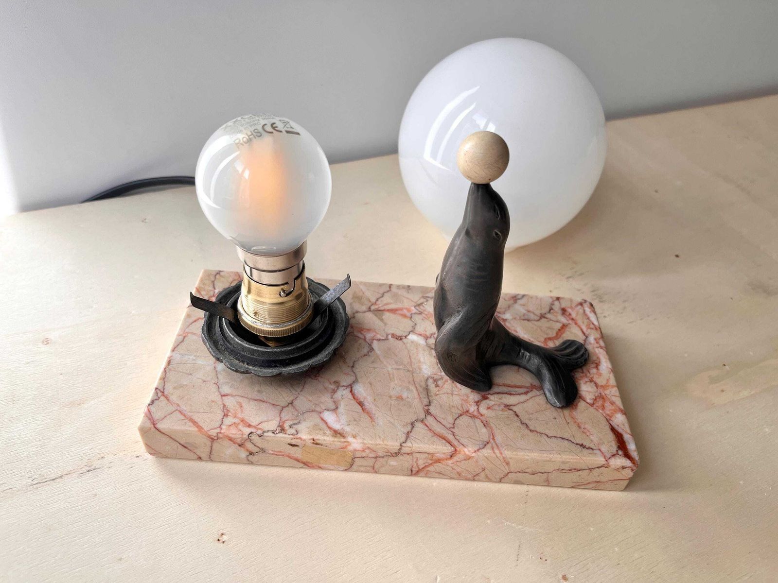 Antiek art deco tafellampje in marmer en spelter, "The Sea Lion Playing With Balloon", bolverlichting jaren 1930 photo buy