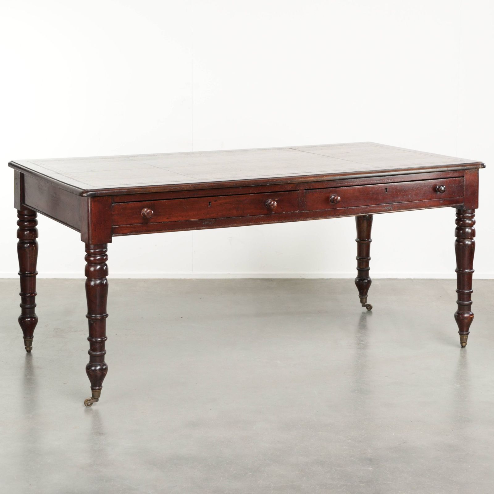 Antique English Writing Desk From The Late 19th Century With A Warm Wood Color And A Dark Brown Leather Top With Gold Accents.