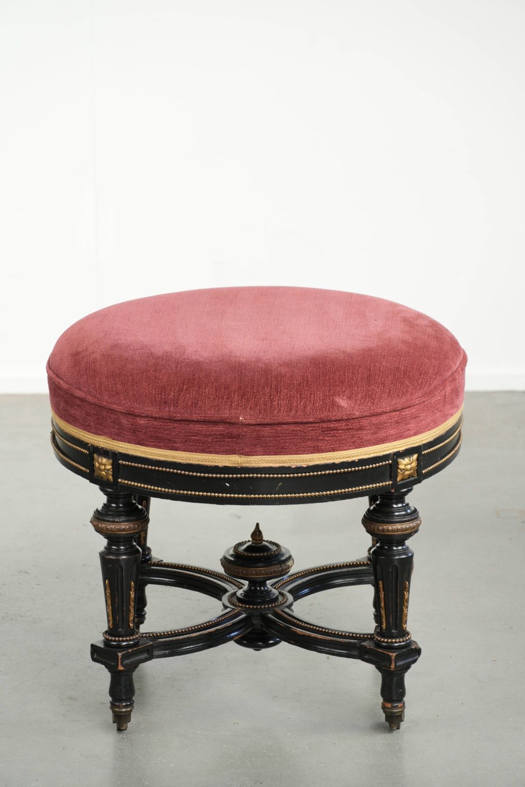 Antieke Engelse kruk met rode stoffen zitting en zwart houten onderstel met goudkleurige details photo 662.0