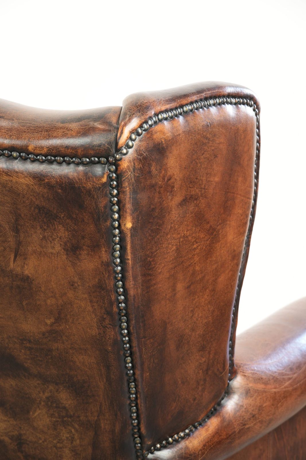 photo vinterior Ruime Vintage Schapenleren Oorfauteuil In Donkerbruin Met Siernagels