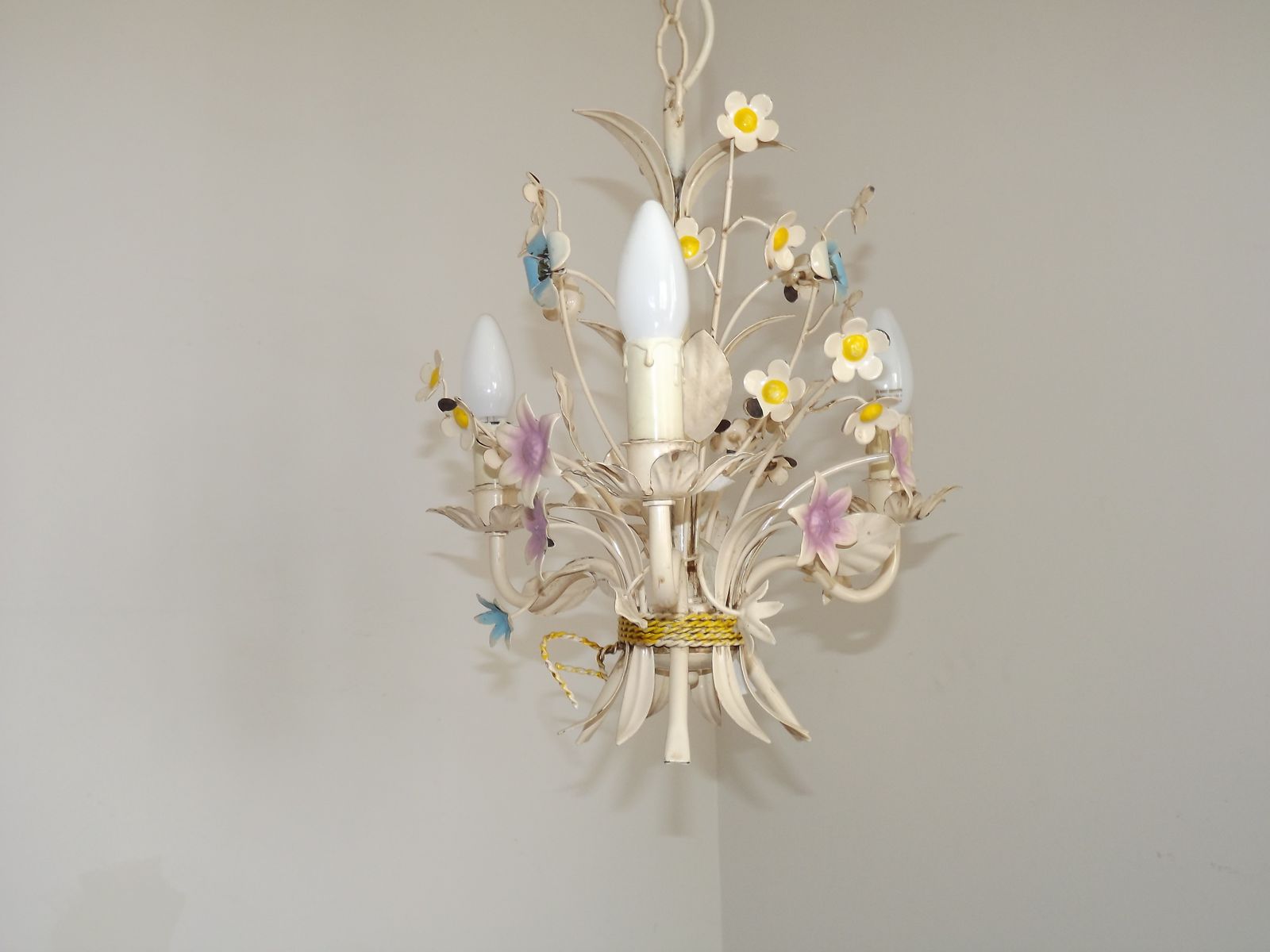 photo vinterior Vintage Franse 3-lichts crème toleware kroonluchter met gebonden boeket en pastelkleurige bloemen.