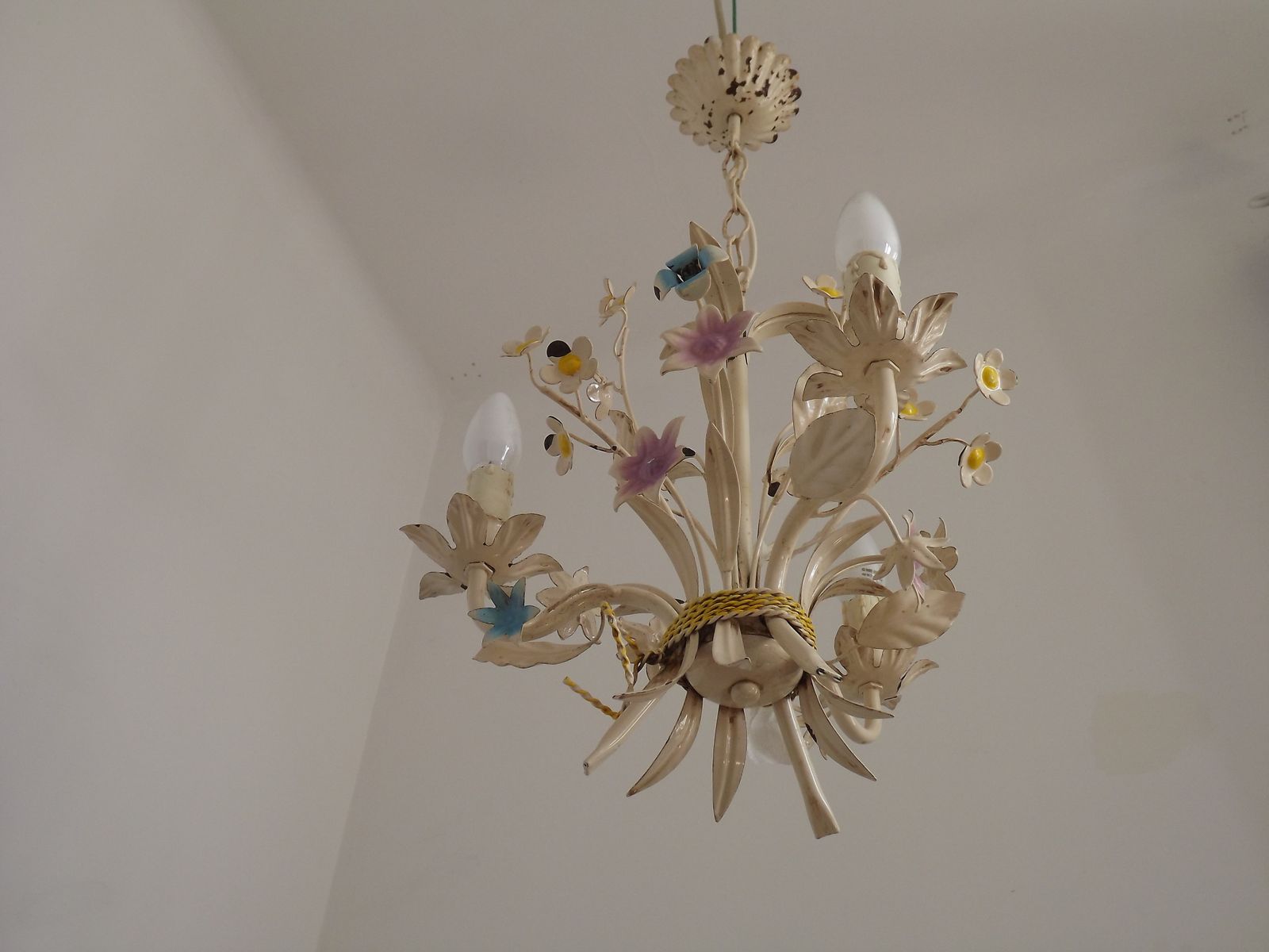 Vintage Franse 3-lichts crème toleware kroonluchter met gebonden boeket en pastelkleurige bloemen.