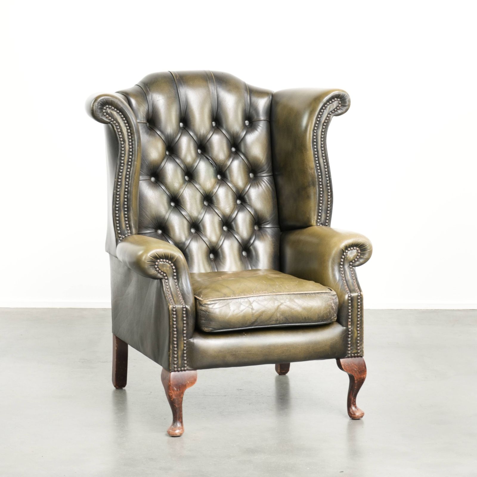 Karaktervolle groene koeienleren Chesterfield fauteuil met vleugelleuningen in Engelse stijl