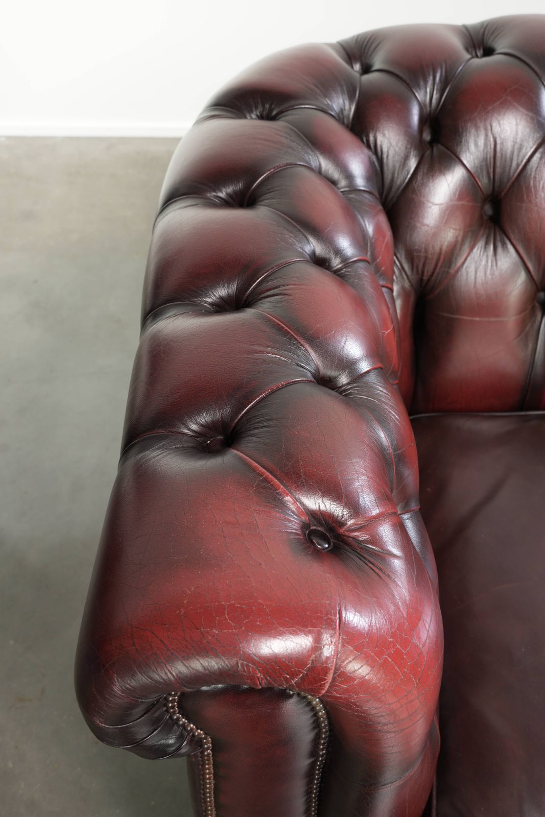 Tijdloze Chesterfield 2,5-zitsbank van koeienhuid in oxblood rood met mooie patina photo buy