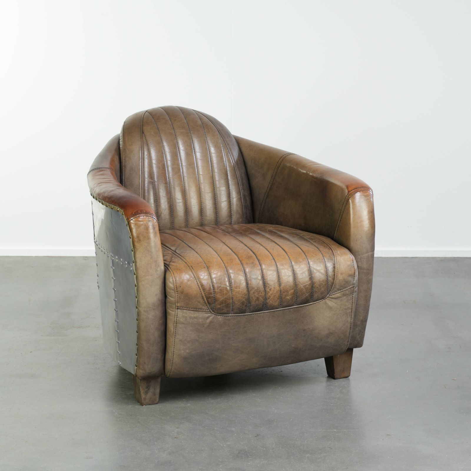 Stoere en karaktervolle fauteuil in aviatorstijl van koeienhuid leer met een unieke aluminiumafwerking