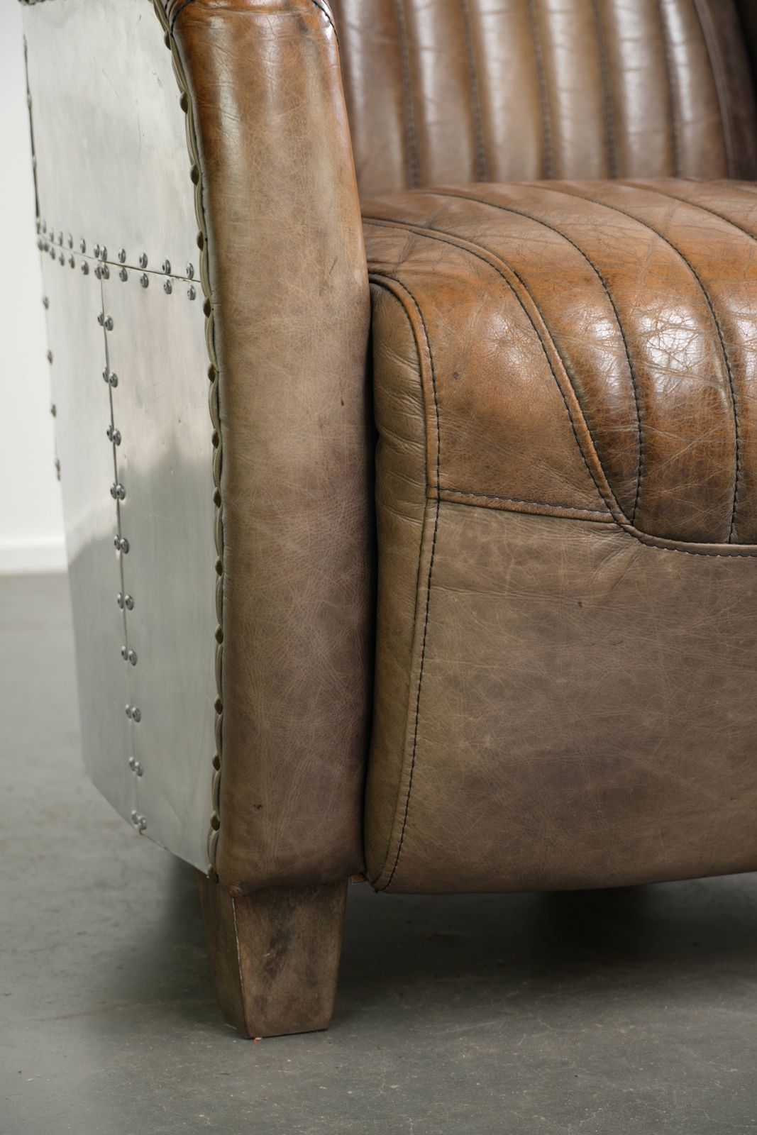 Meubels Stoere en karaktervolle fauteuil in aviatorstijl van koeienhuid leer met een unieke aluminiumafwerking photo