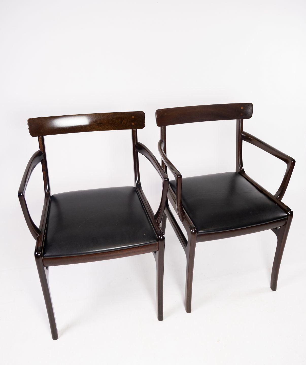 A Pair Of Rungstedlund Armchairs In Mahogany And Uppolstered In Black Leather, By Ole Wanscher And P. Jeppesen.