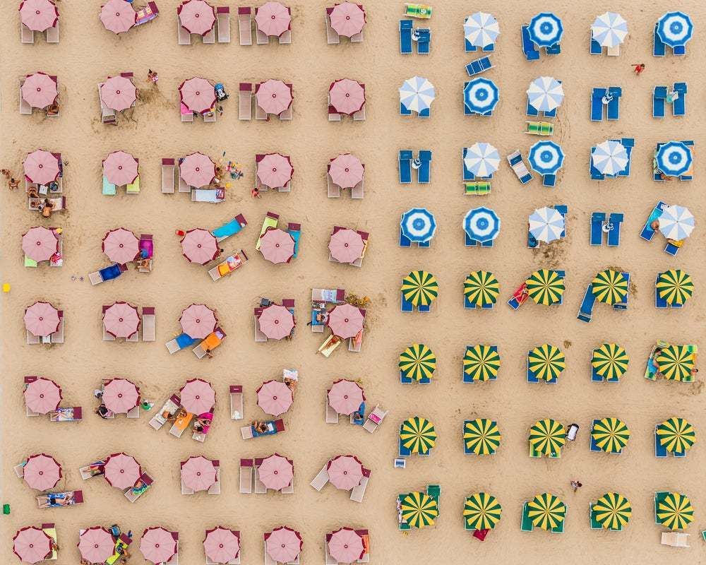 "Aerial View Of Sunshades Standing In The Sand" By Bernhard Lang