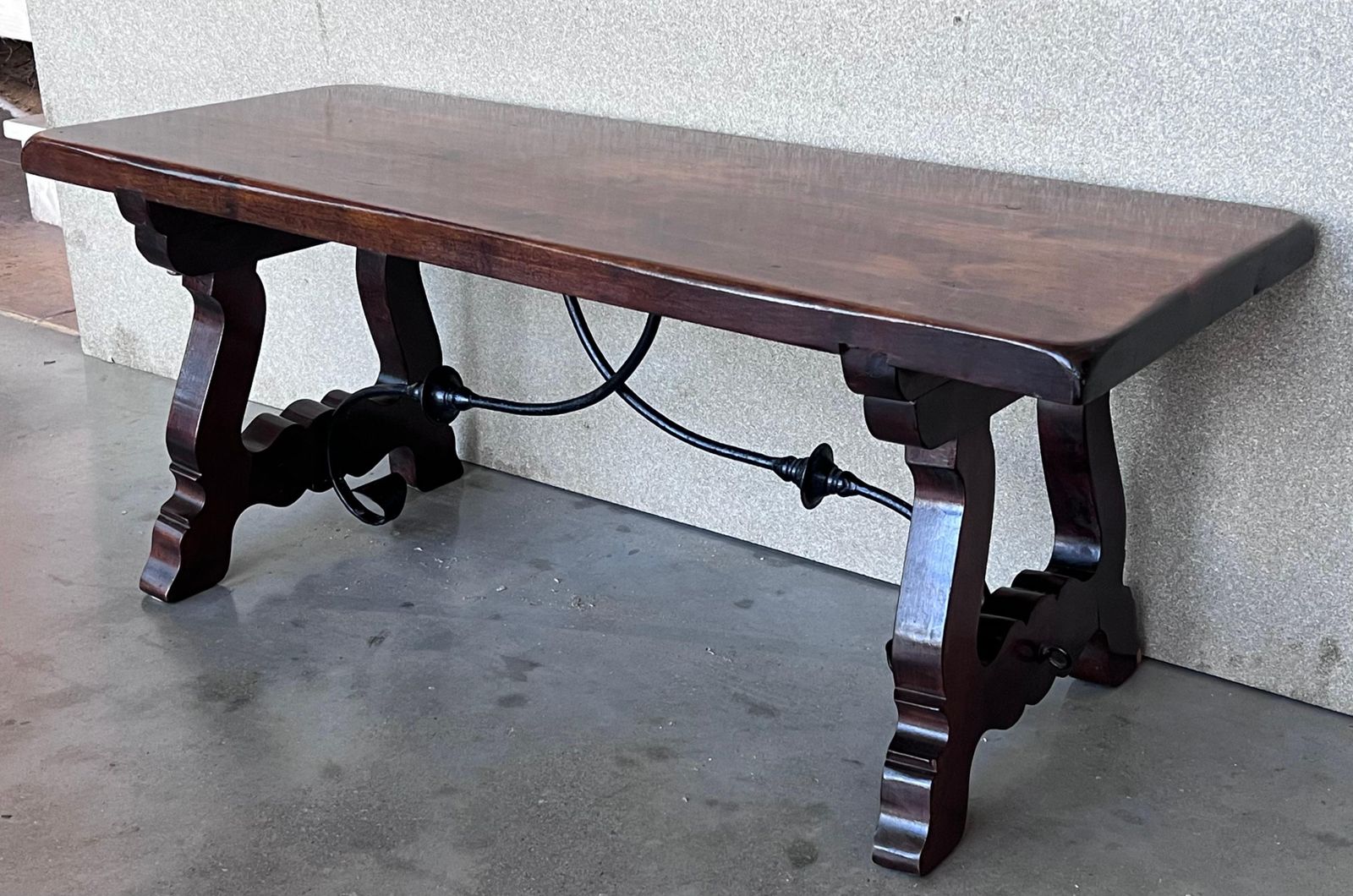 Table espagnole sculptée du XXe siècle avec traverses en fer photo vinterior