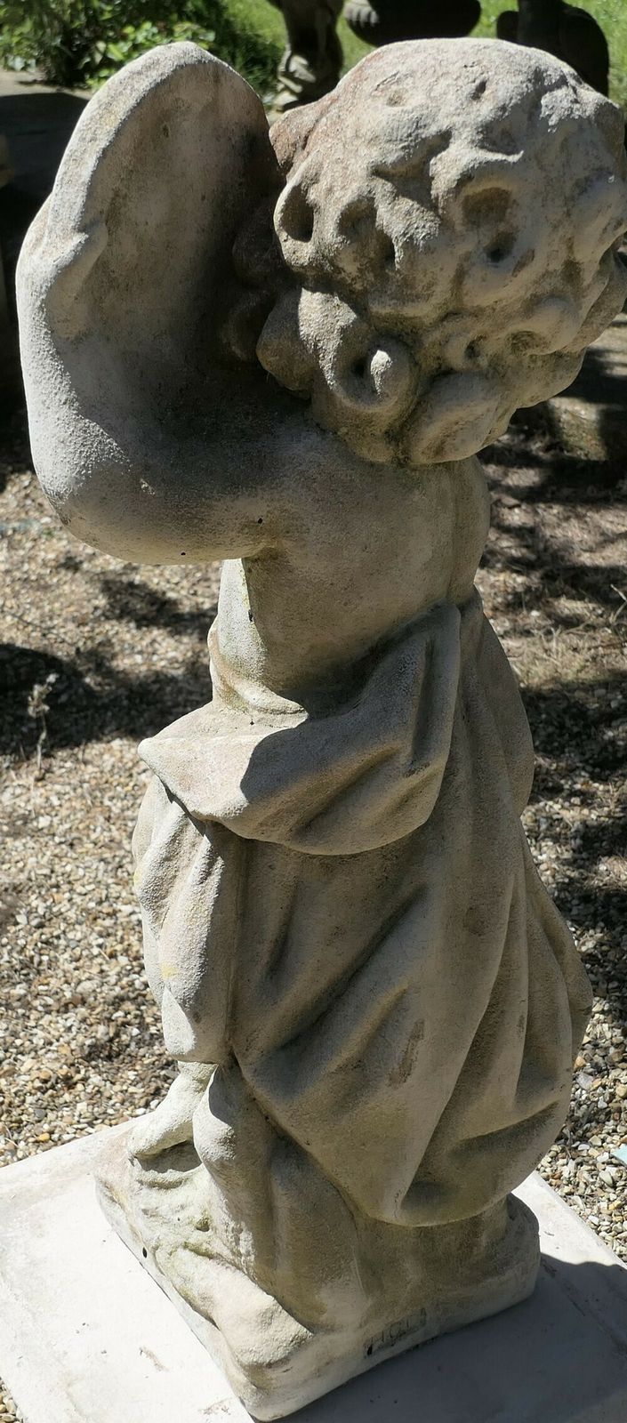 Old Weathered Statue Of A Putti Playing Tambourine photo 450.0