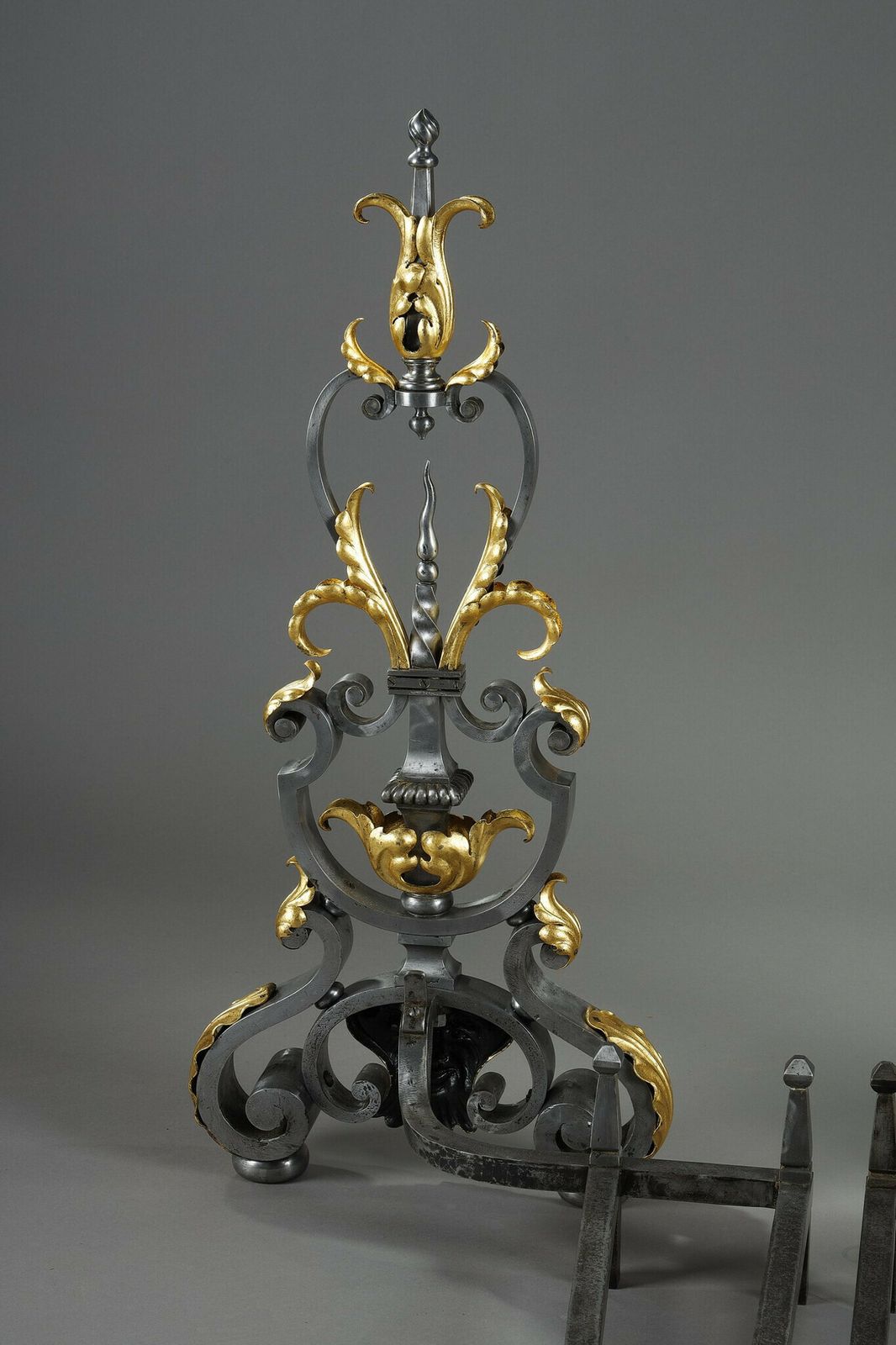 photo furniture Pair Of Wrought Iron Landiers With Foliage, Mask And Scroll Decoration