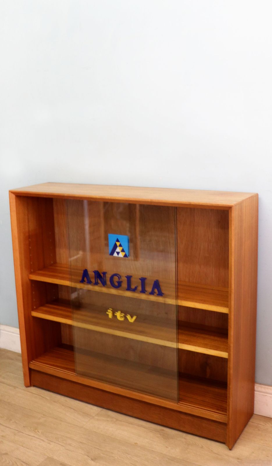 A Mid Century Gibbs Display Cabinet With The Anglia Television Logo. photo 495.0