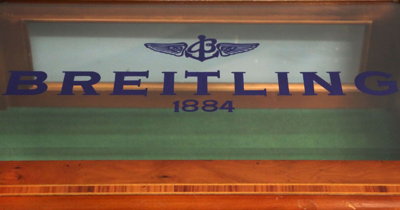 A Lovely Yew Wood Veneered Bijouterie Display Table, Later Sign Written For Breitling Watches. photo vinterior