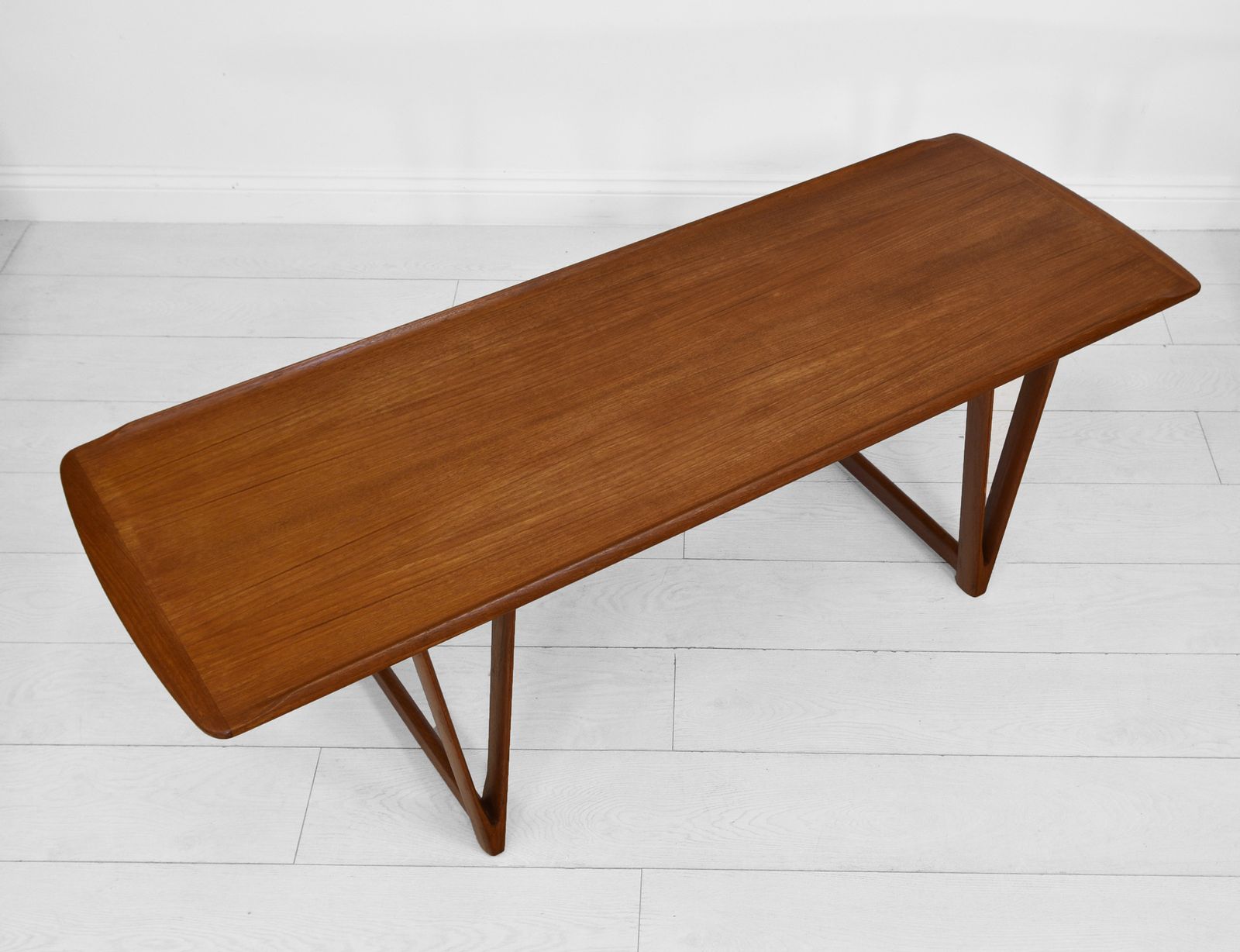 photo furniture Mid Century Danish Teak Coffee Table On V Shape Supports And Lipped Top Edge