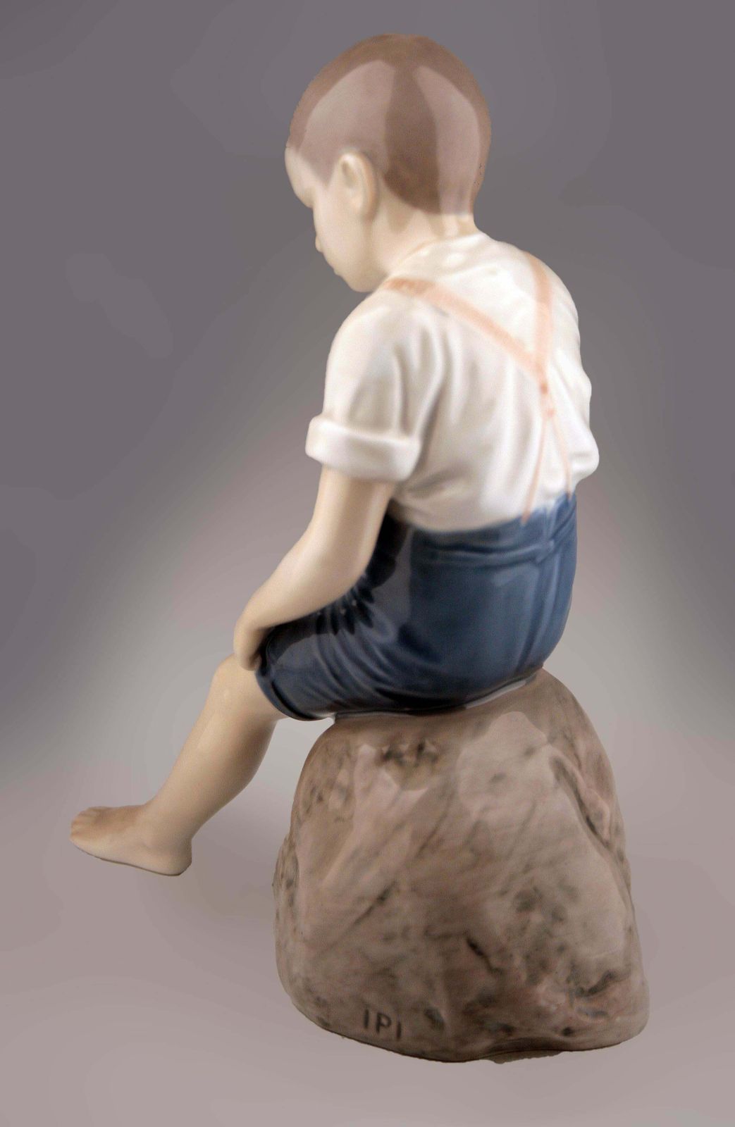 Mid 20th Century Scandinavian Modern Glazed Porcelain Sculpture Of A Boy Sitting On A Rock By Danish Company Bing & Grøndahl photo for sale