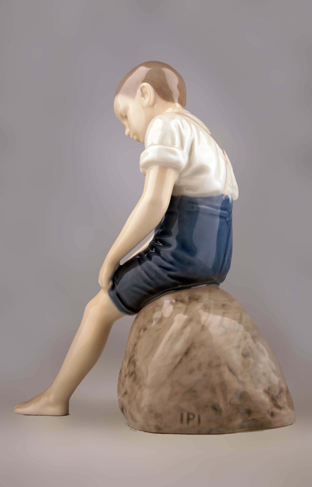 Mid 20th Century Scandinavian Modern Glazed Porcelain Sculpture Of A Boy Sitting On A Rock By Danish Company Bing & Grøndahl photo vinterior