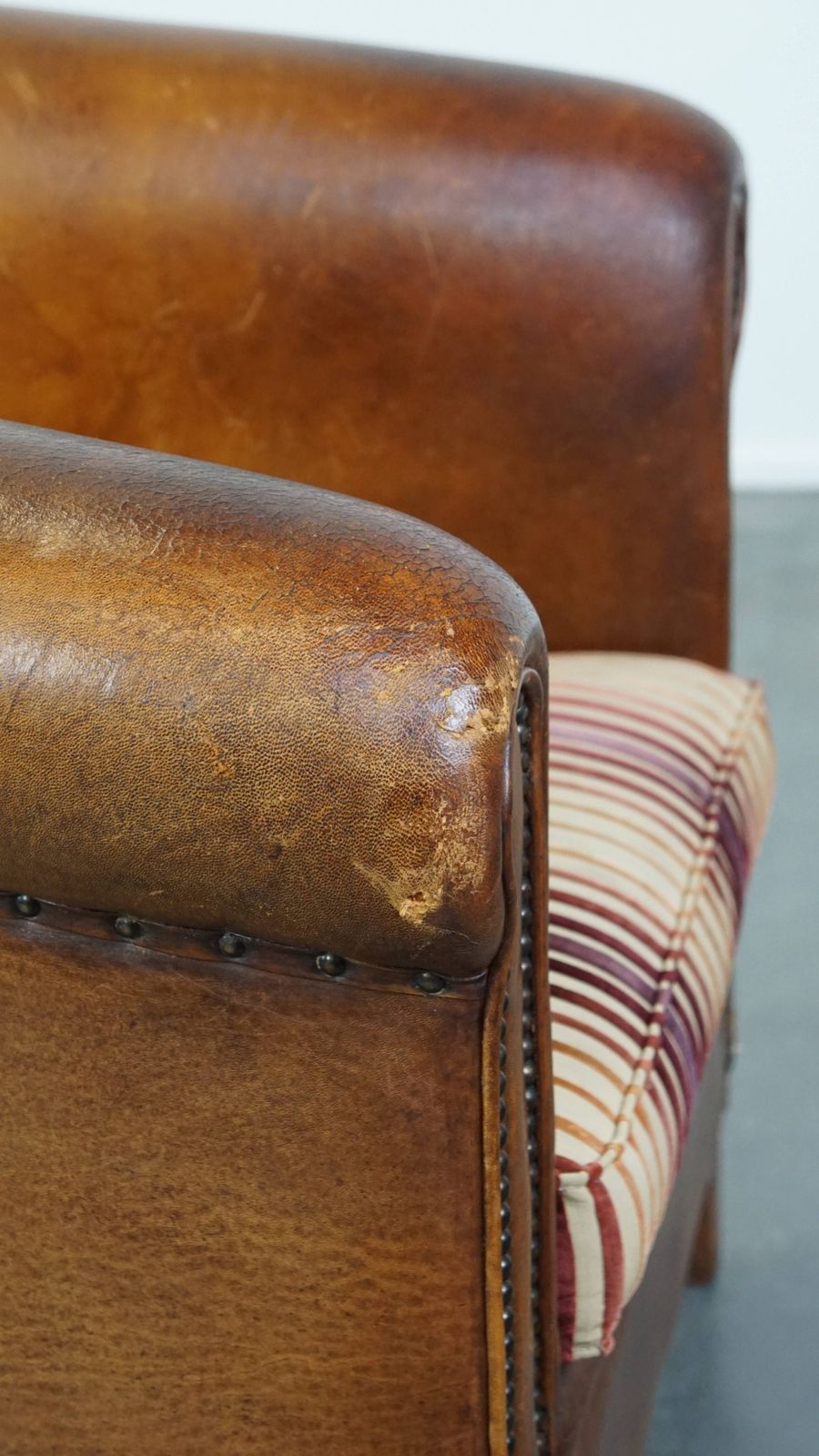 photo for sale Characterful Vintage Cognac Colored Club Chair Made Of Sheepskin With A Colorful Fabric Seat Cushion