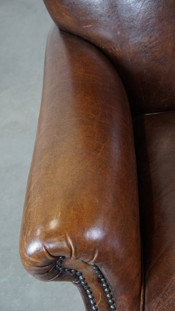 Classic, Dark, Good Condition Sheepskin Armchair With Beautiful Round Shapes And On Wheels photo vinterior