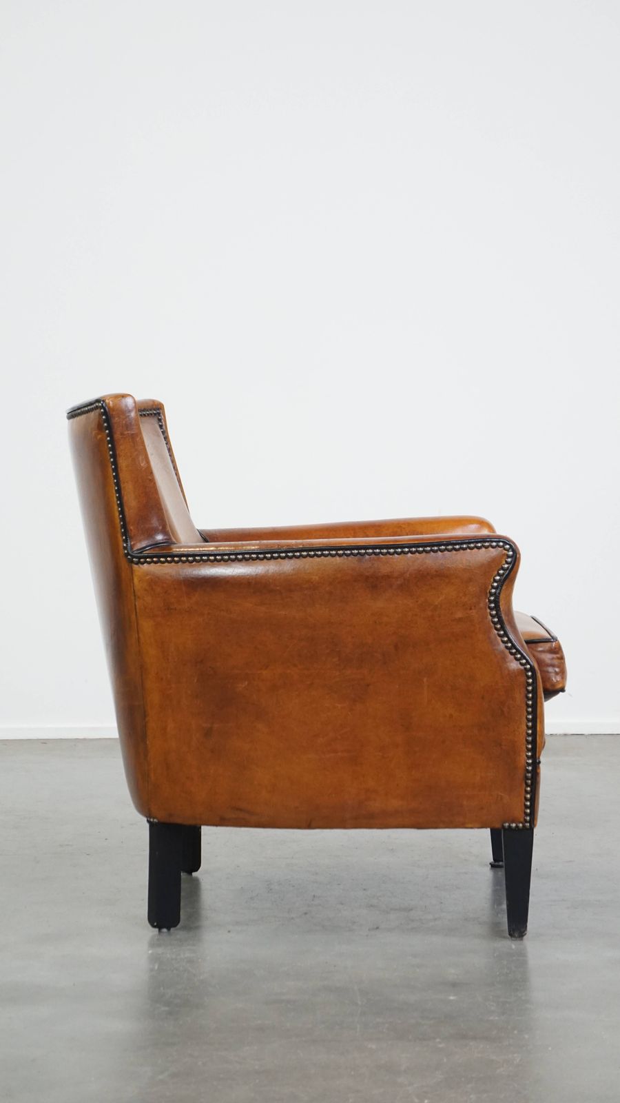 Subtle Cognac Colored Sheepskin Armchair With A Nice Design And Finish With Black Piping And Decorative Nails photo for sale