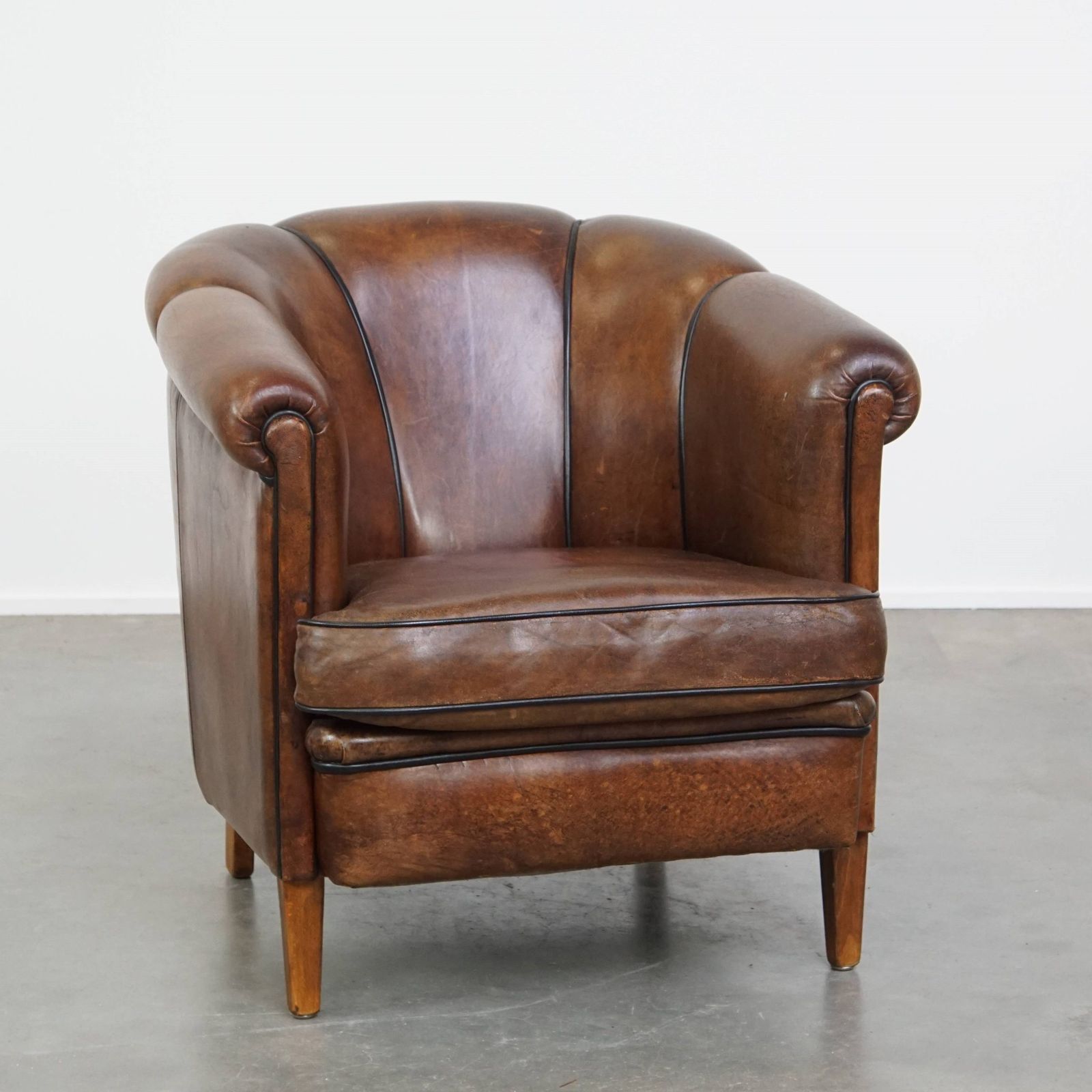 Bijzondere En Statige Clubfauteuil Van Donker Schapenleer Met Zwarte Paspelafwerking