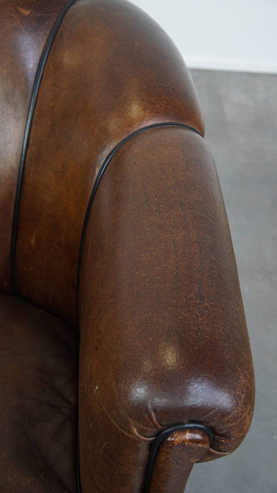 Special, Characteristic And Stately Dark Sheepskin Club Chair With A Black Piping Finish photo vintage